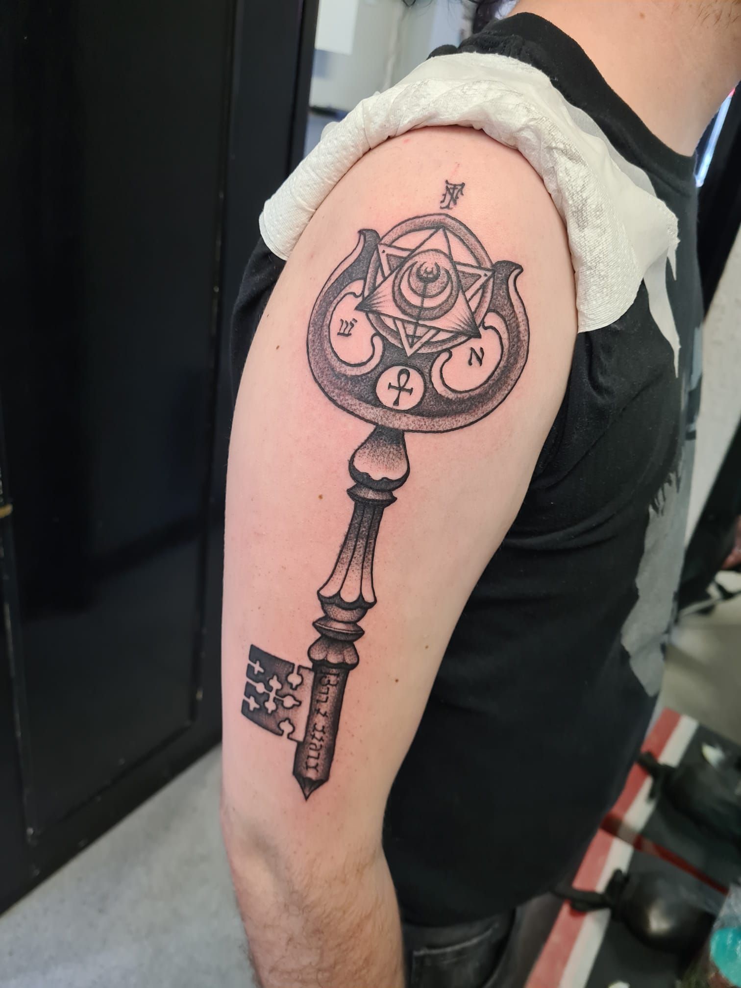 A man has a tattoo of a key on his arm.