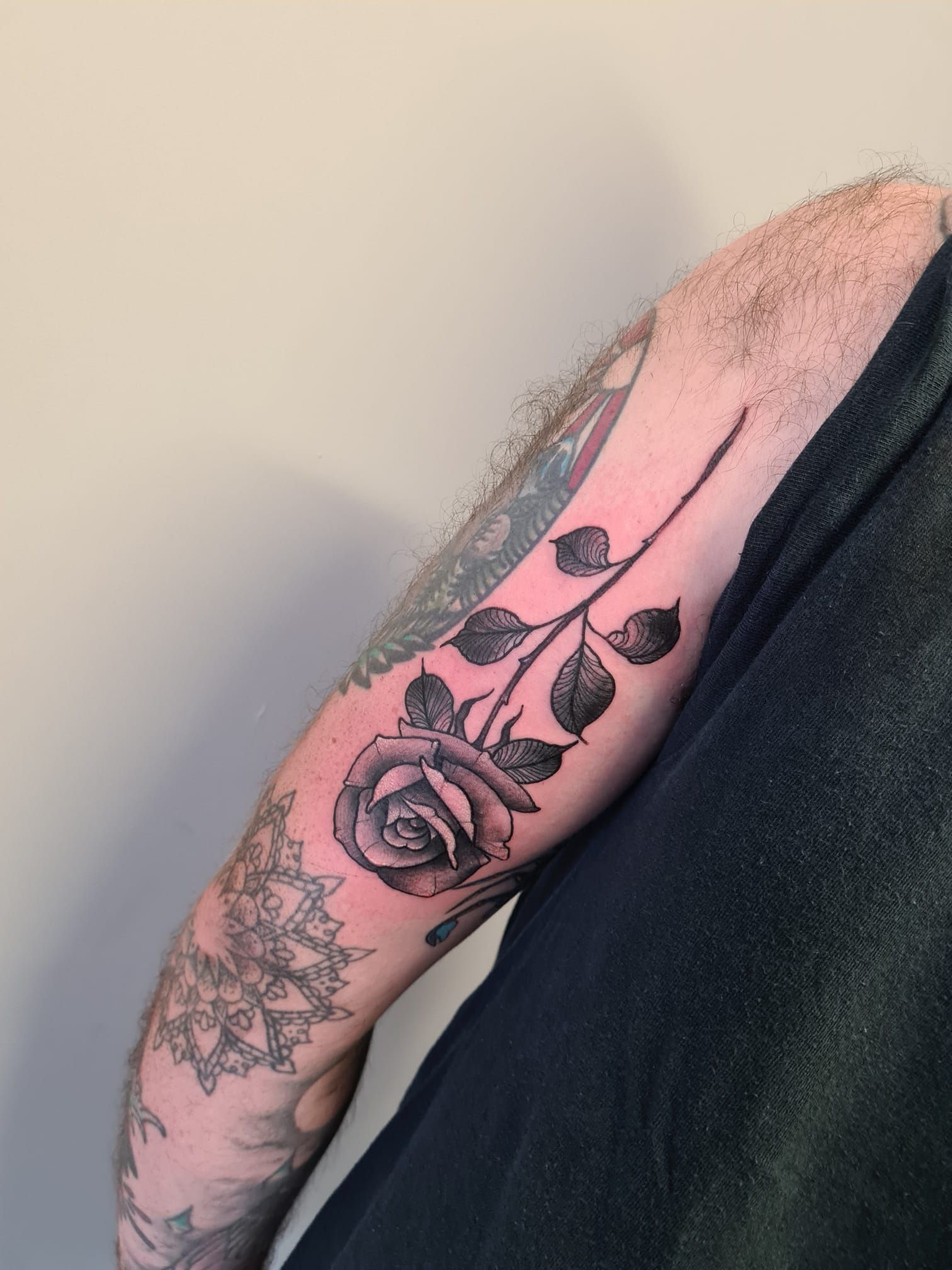 A man has a tattoo of a rose on his arm