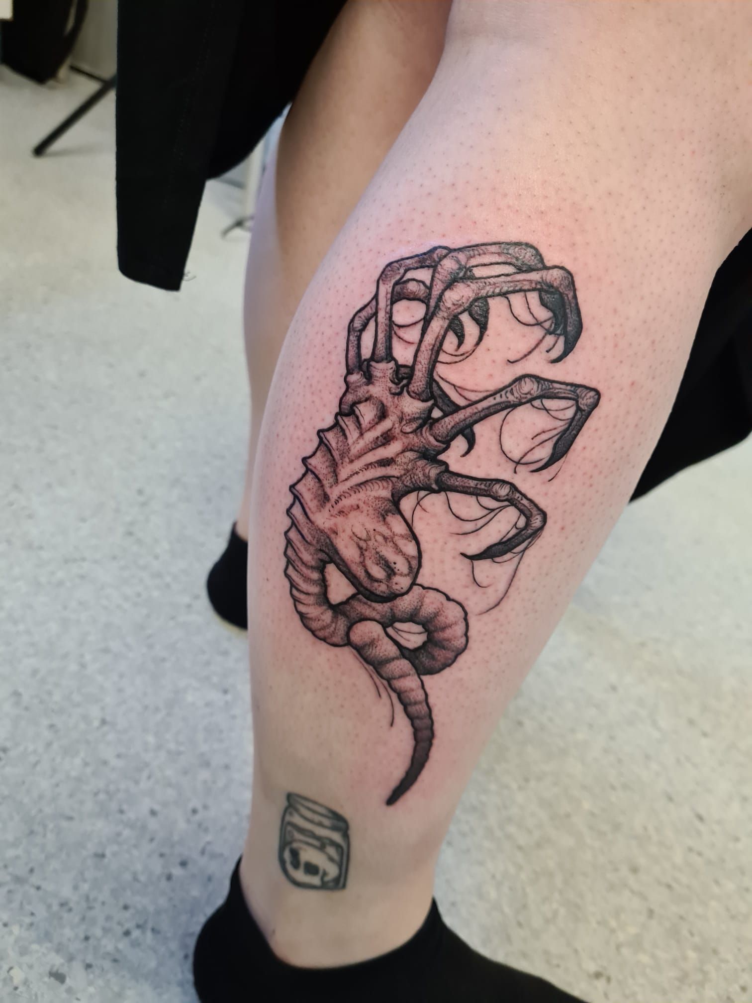 A person has a tattoo on their leg with the number 9 on the ankle