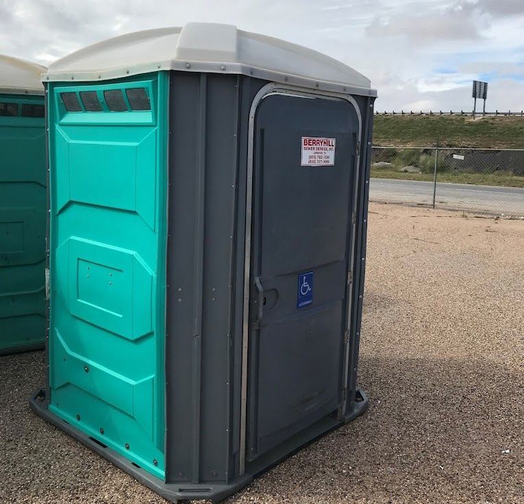 A Blue Portable Toilet in the Middle of a Forest — Lubbock, TX — Berryhill Sewer Inc.