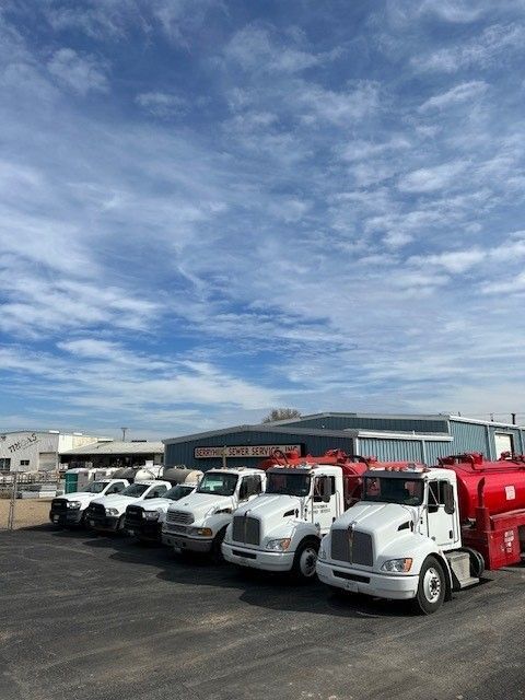 A Row of Trucks are Parked in Front of a Building — Lubbock, TX — Berryhill Sewer Inc.
