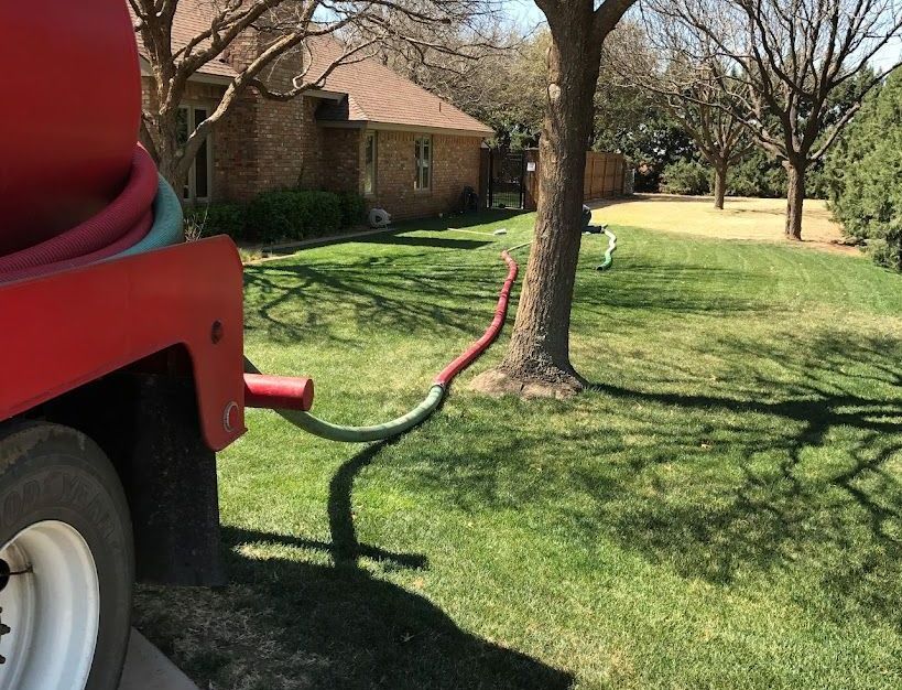 A Green Hose is Coming Out of a Manhole Cover — Lubbock, TX — Berryhill Sewer Inc.