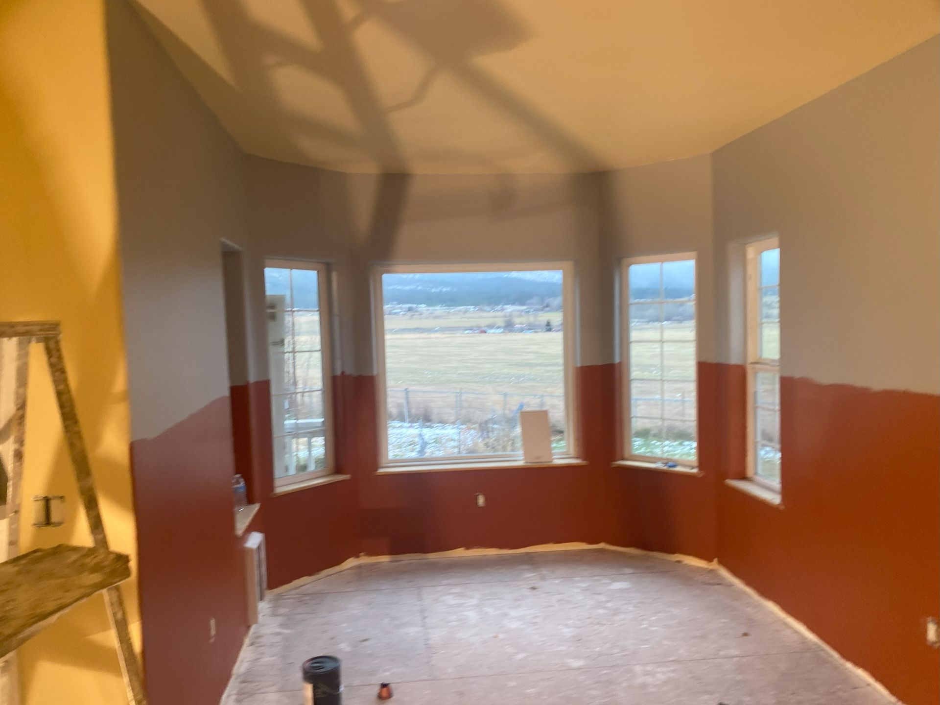 A room with red and gray walls and a large window.
