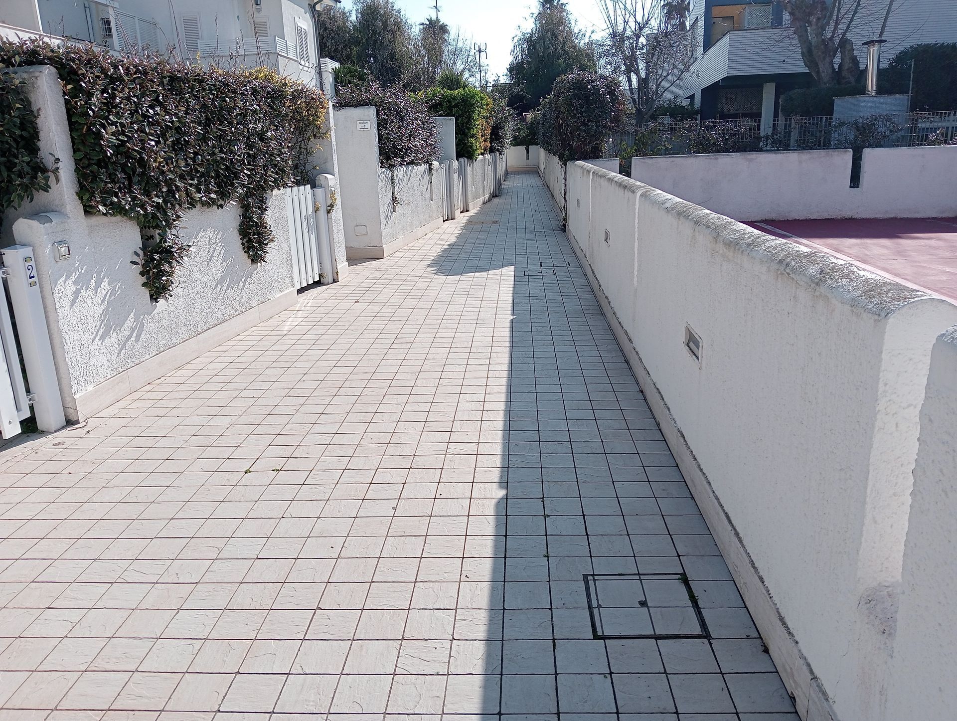 Una passerella in mattoni con un muro bianco lungo il lato