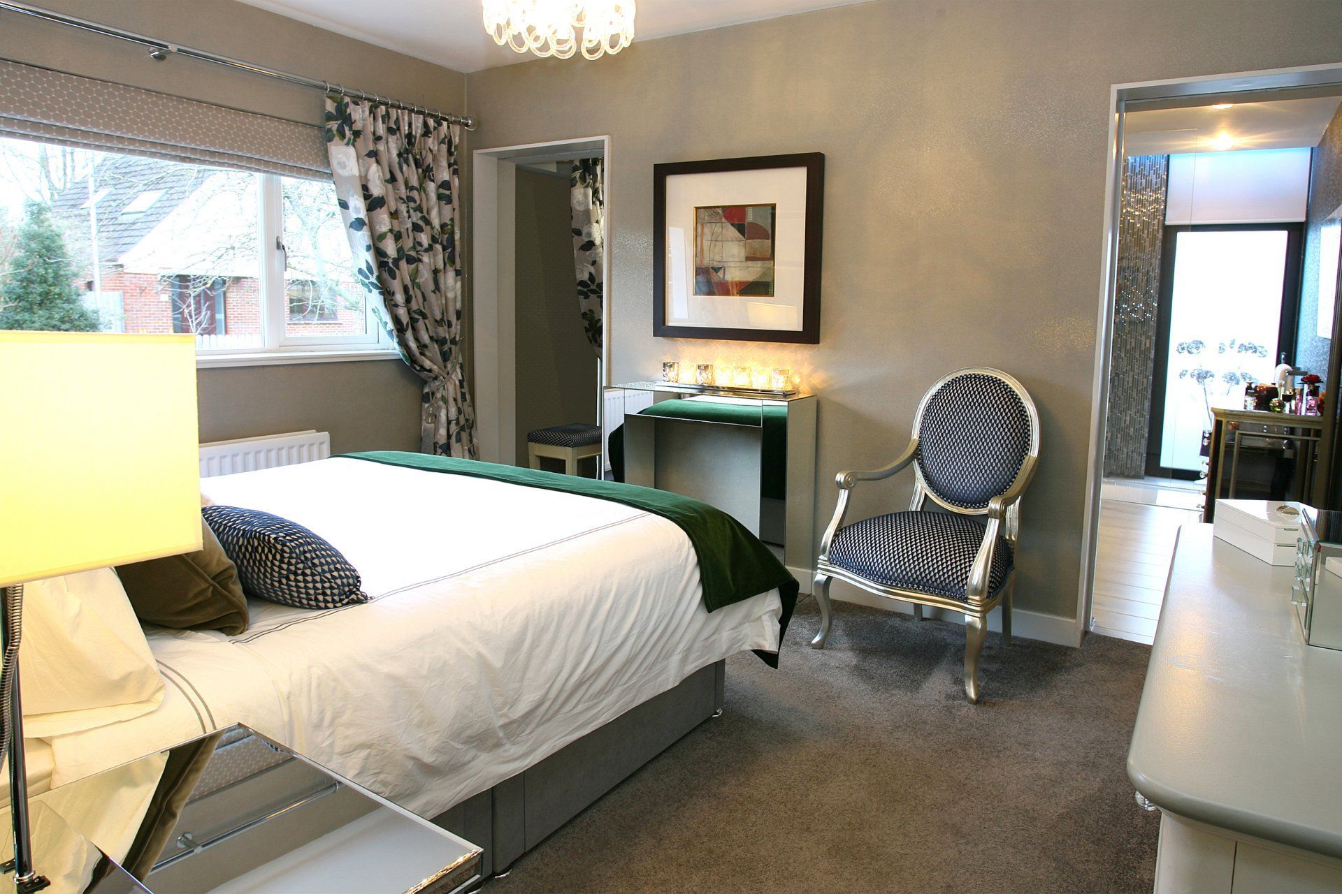 A bedroom with a large bed and a chair