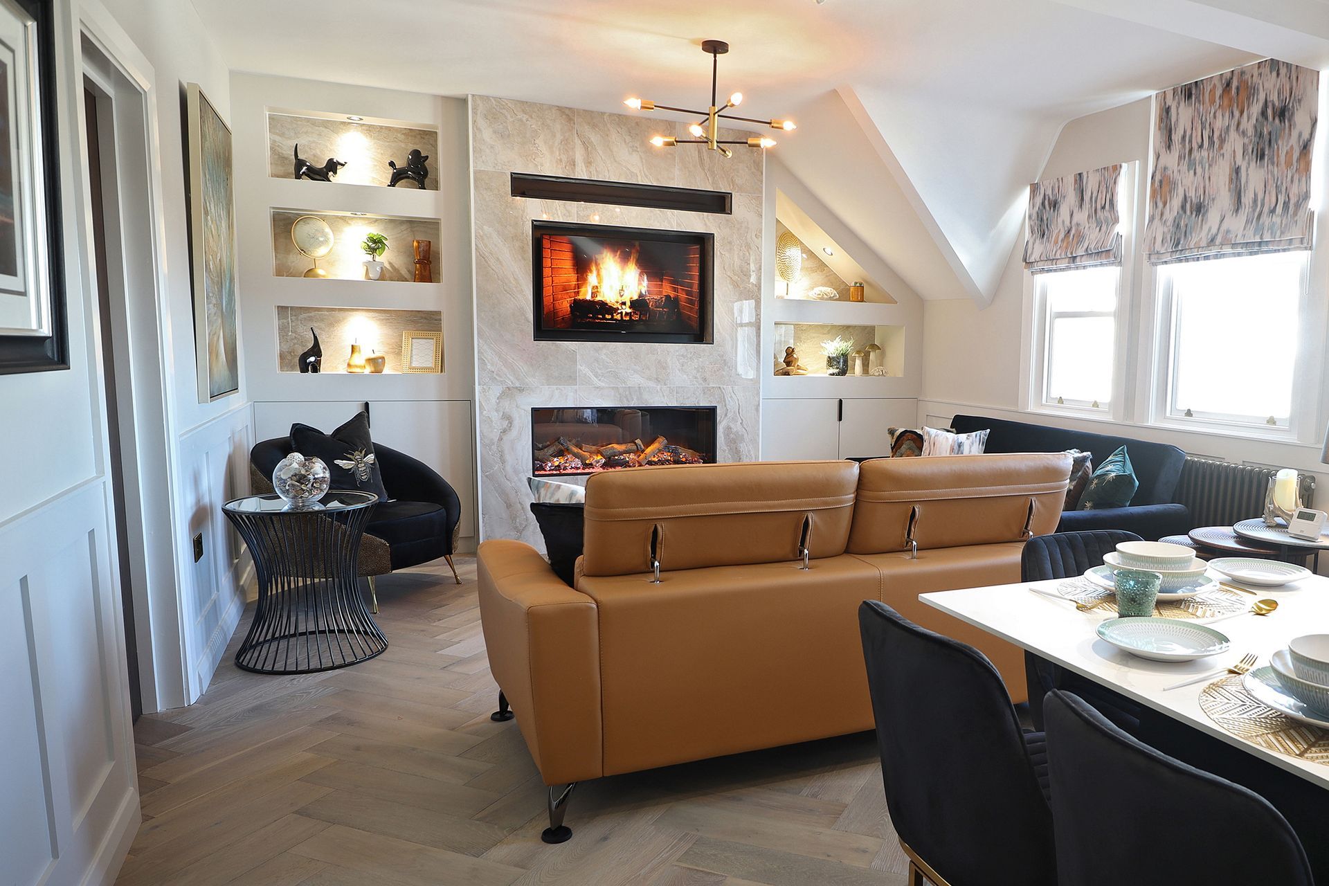 A living room with a fireplace , couch , table and chairs.