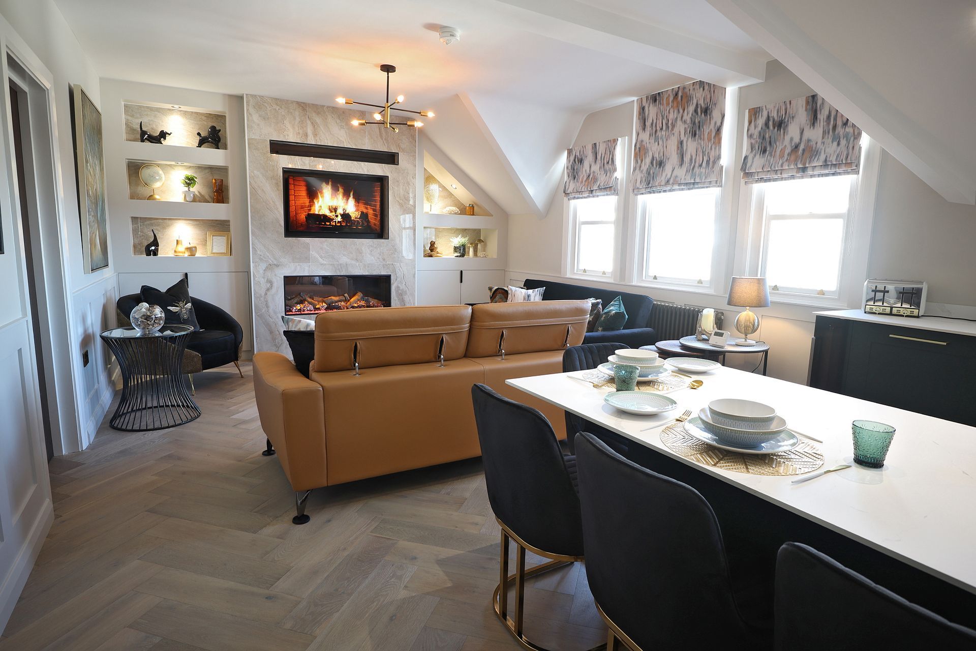 A living room with a couch , table and chairs and a fireplace.