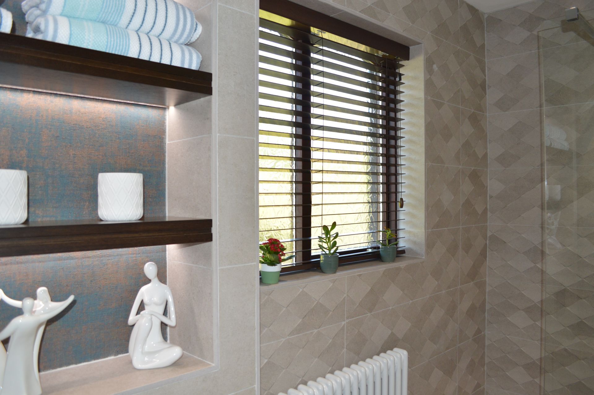 A bathroom with a window , shelves , and a radiator.