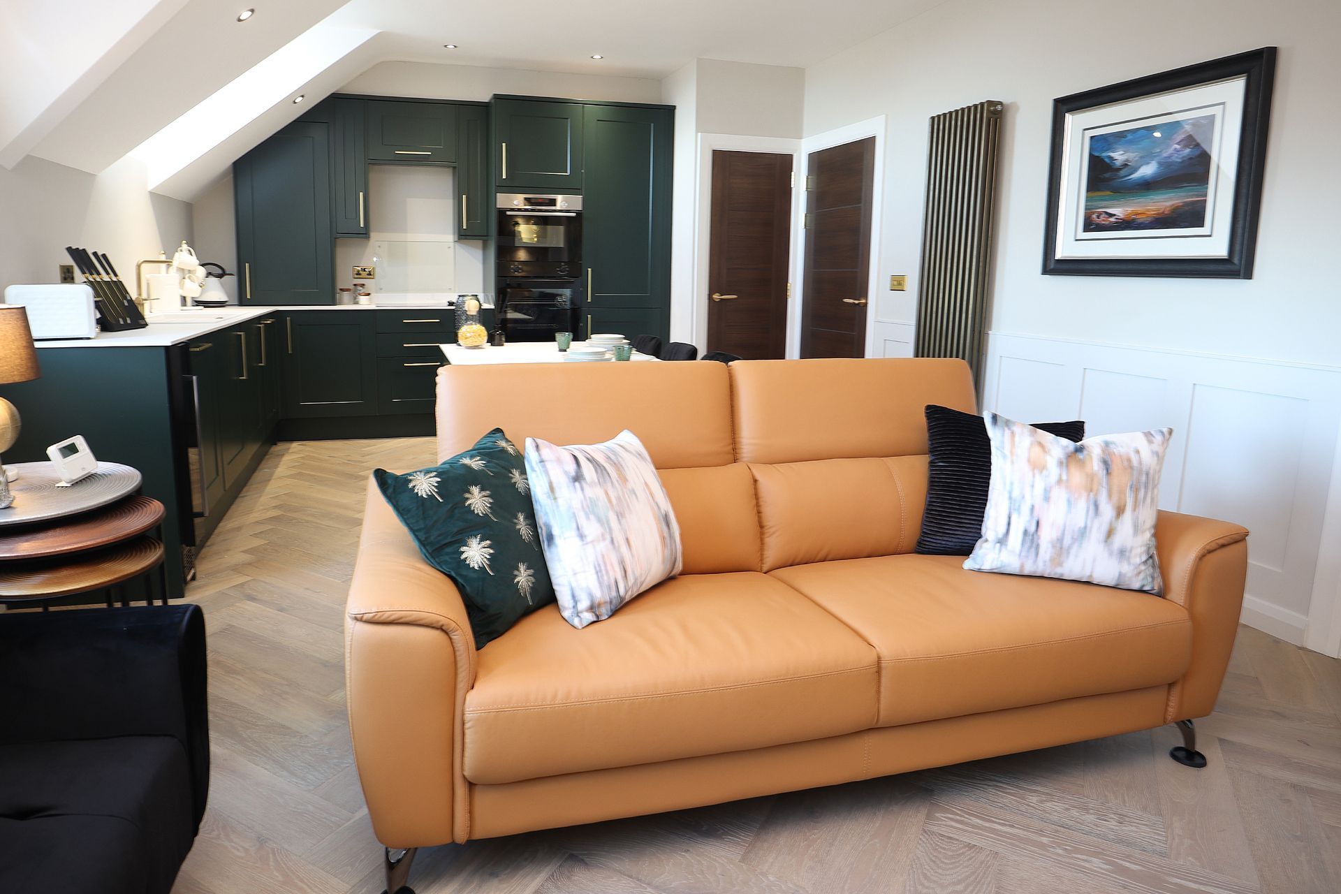 A living room with a couch and a kitchen in the background.