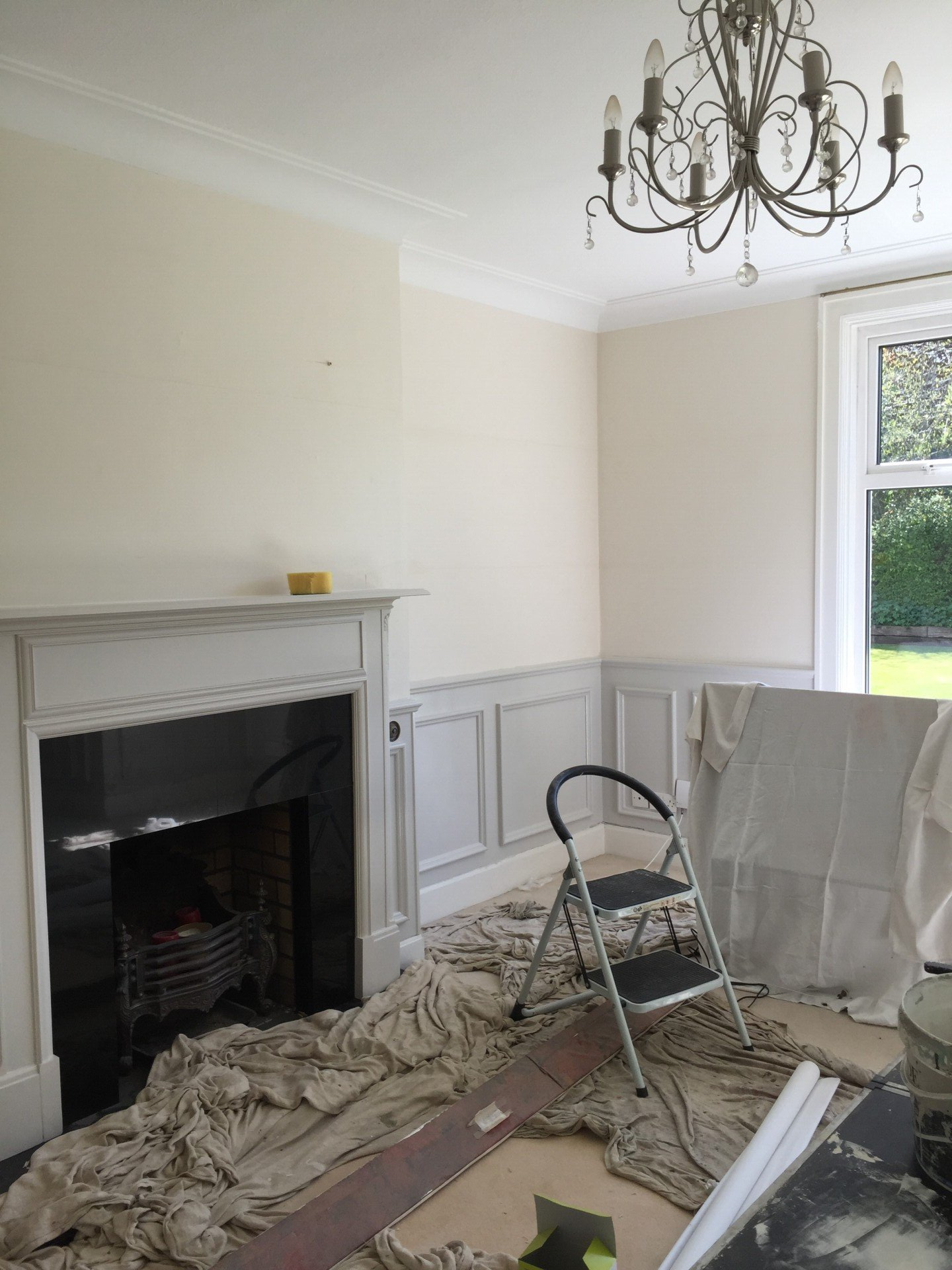 A living room with a fireplace and a chandelier.