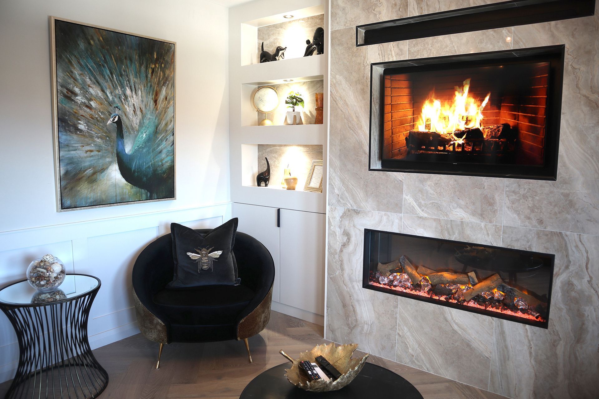 A living room with a fireplace and a painting of a peacock on the wall.