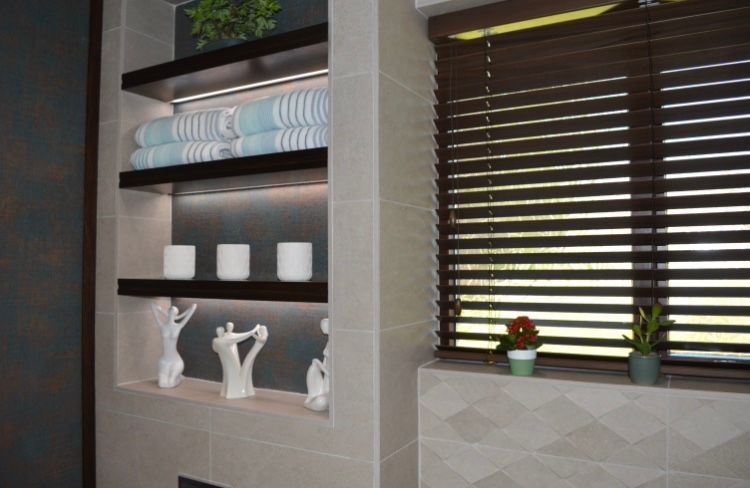 A bathroom with shelves and a window with blinds