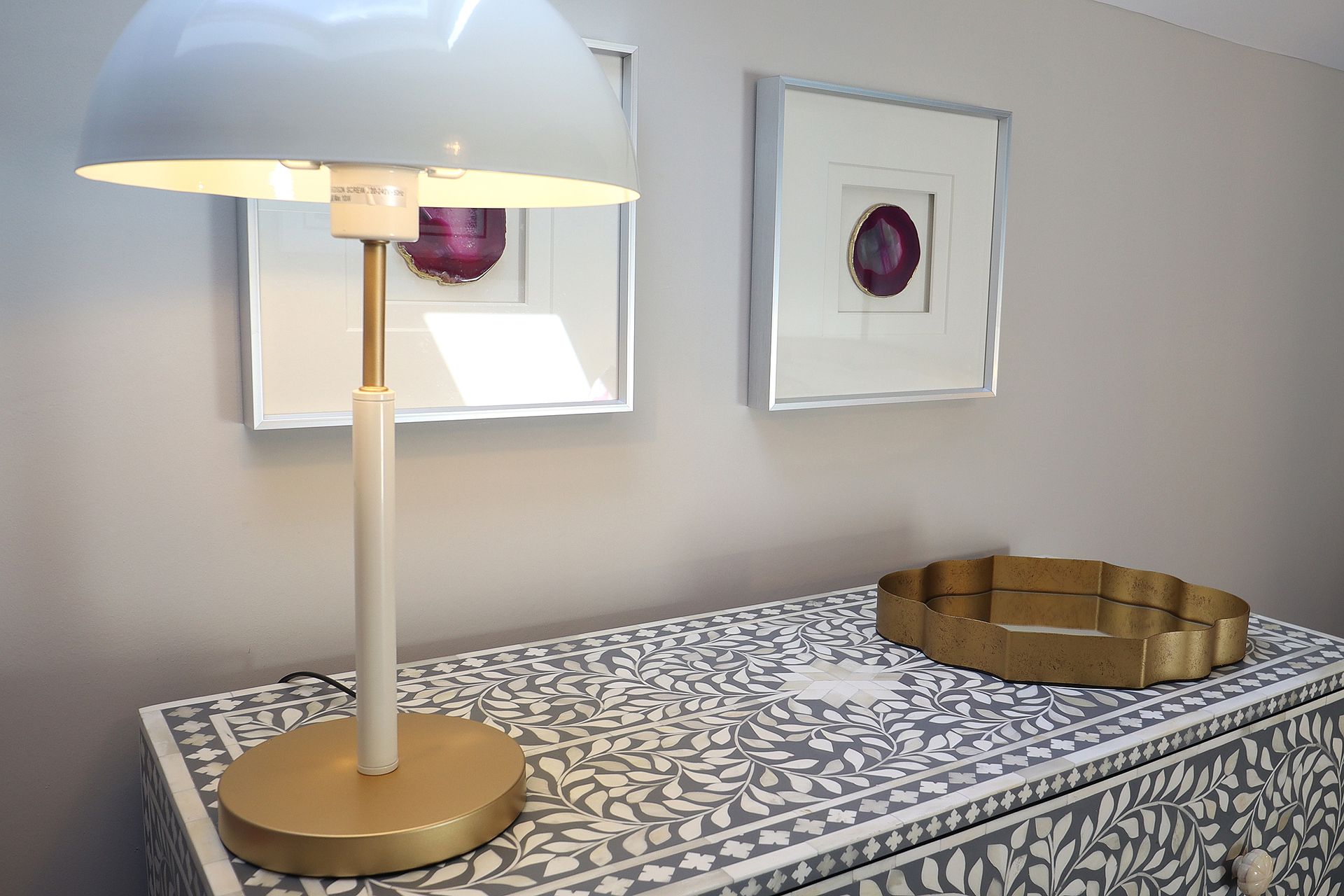 A lamp is sitting on top of a dresser in a room.