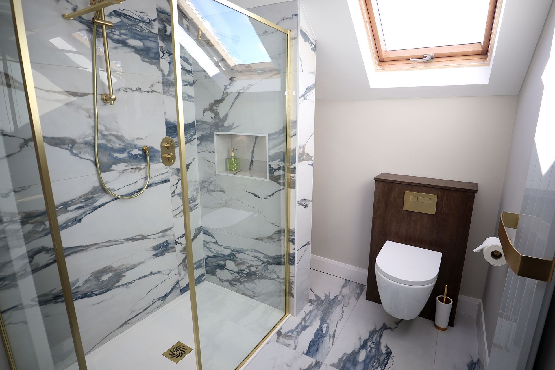 A bathroom with a walk in shower , toilet , and skylight.