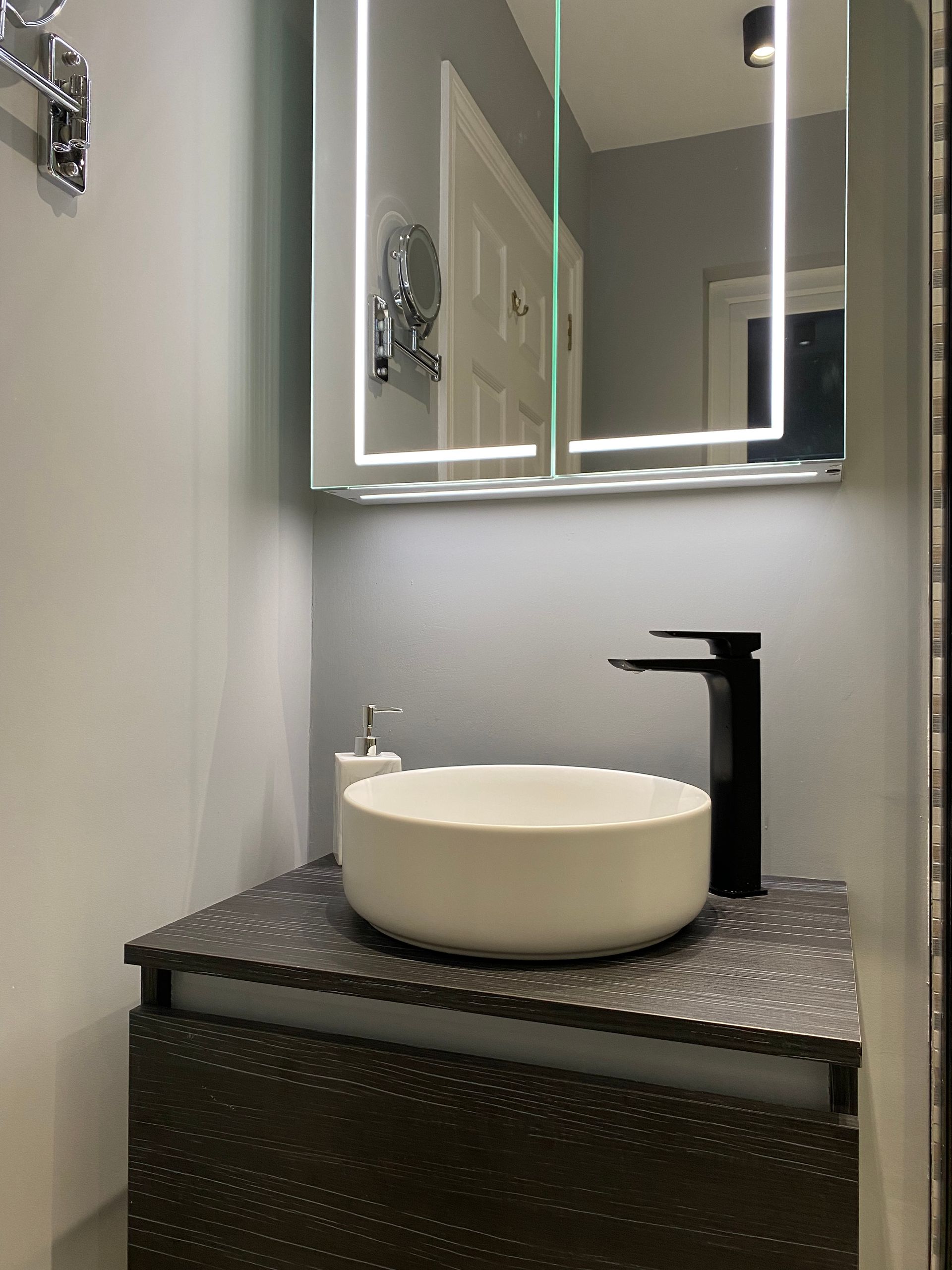 A bathroom with a sink , mirror and faucet.