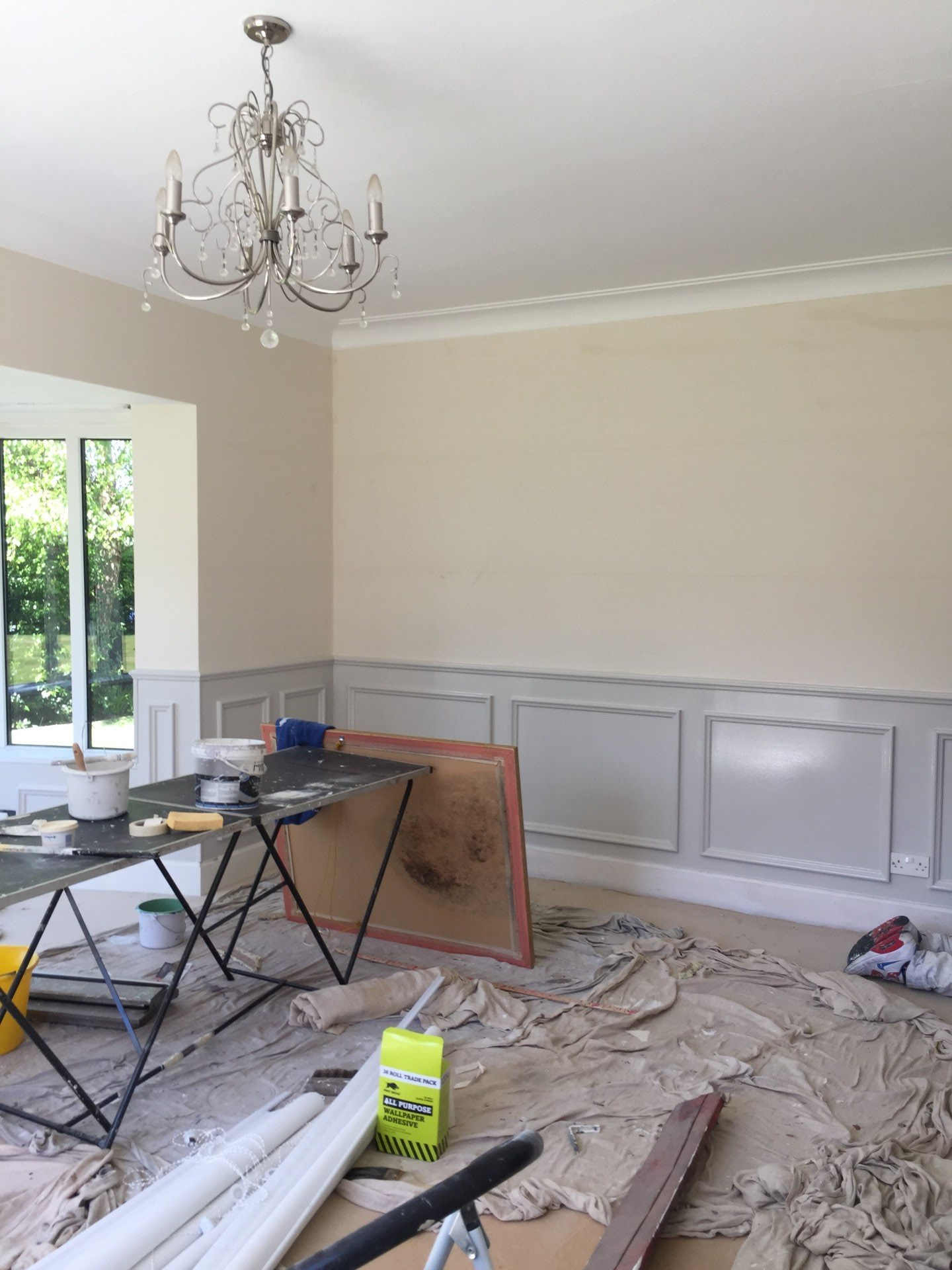 A room with a table and a chandelier in it.