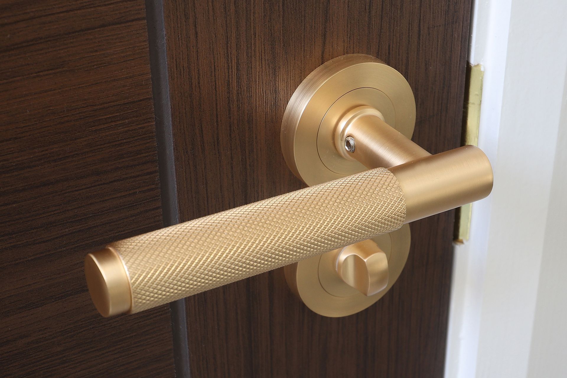 A close up of a door handle on a wooden door.