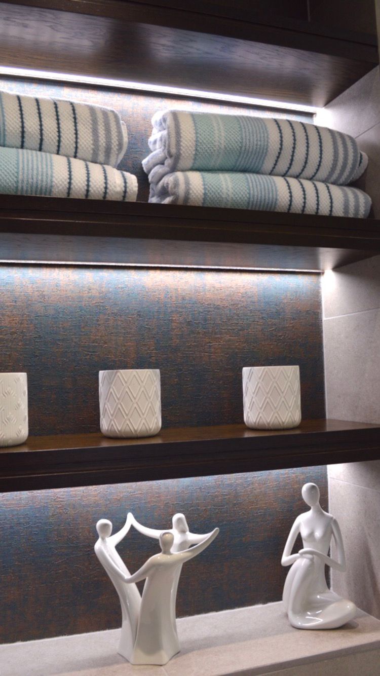 A shelf with towels and a statue of a family on it