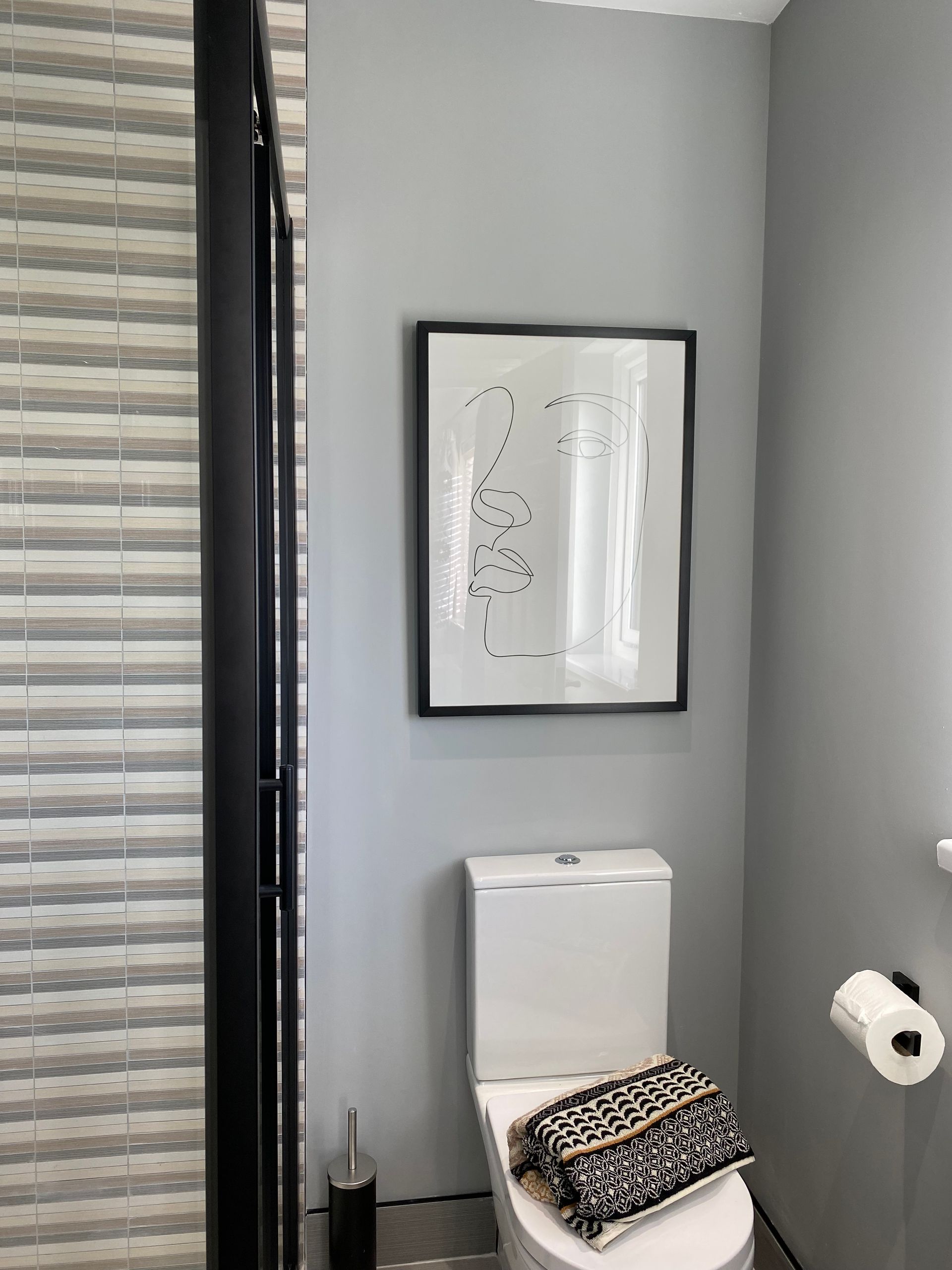 There is a picture on the wall above the toilet in the bathroom.