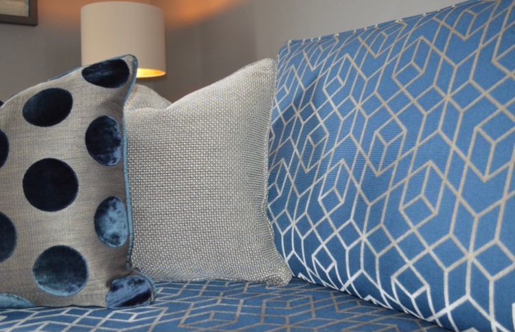 A bed with blue pillows and a lamp on it