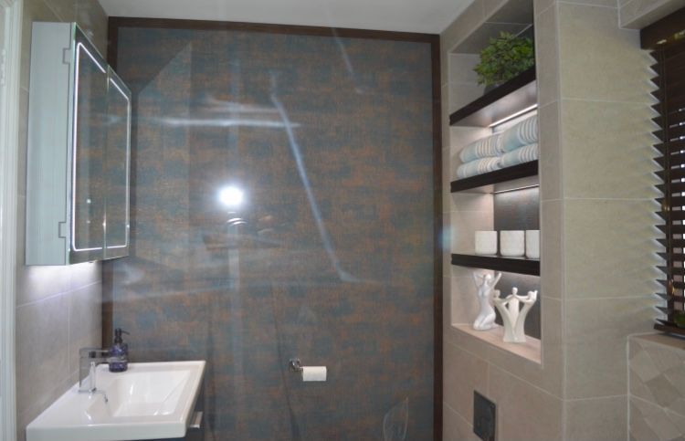 A bathroom with a sink , mirror , shelves and a walk in shower.