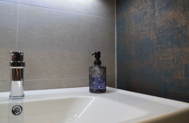 A bathroom sink with a soap dispenser and a faucet.