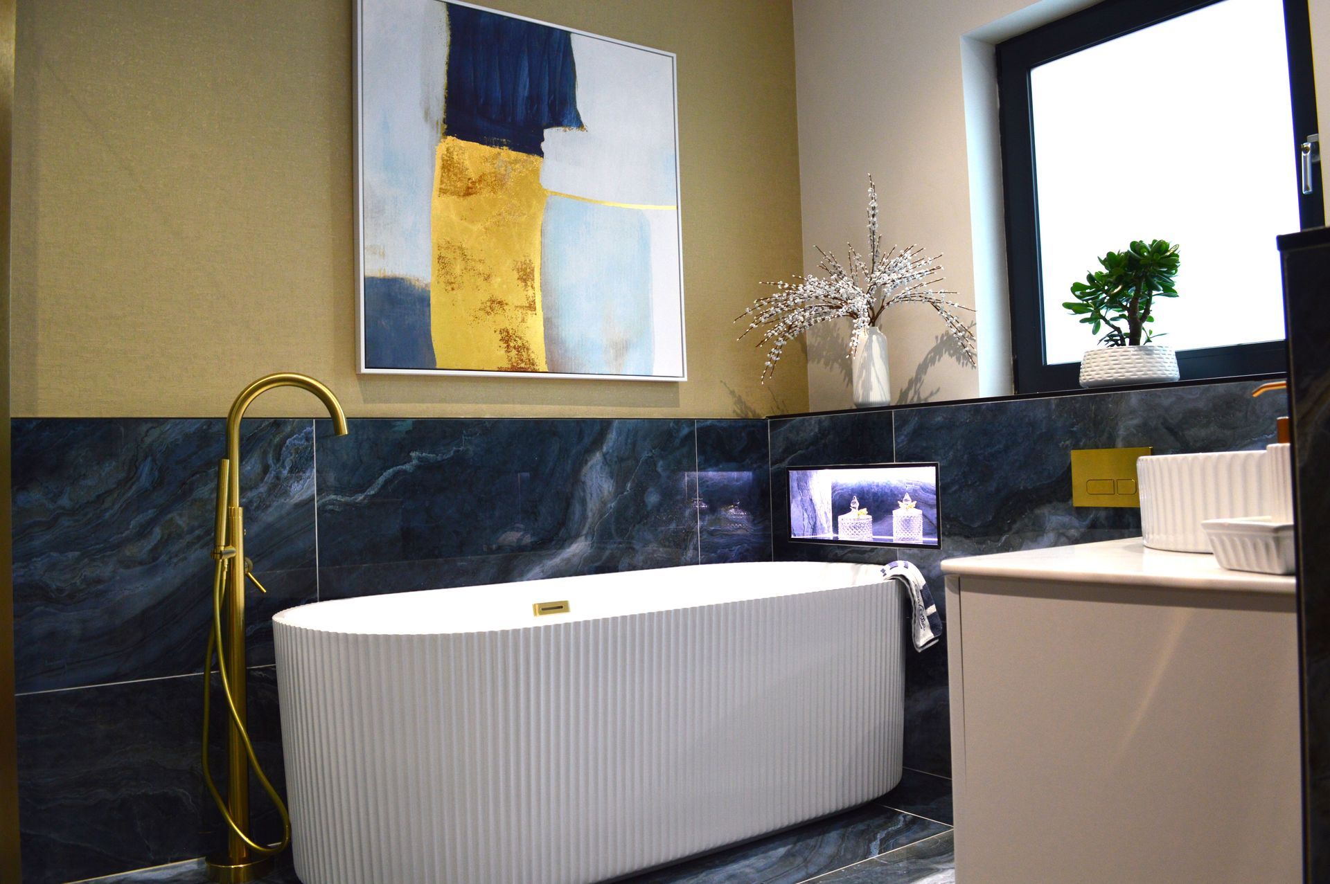 A bathroom with a bathtub and a painting on the wall.