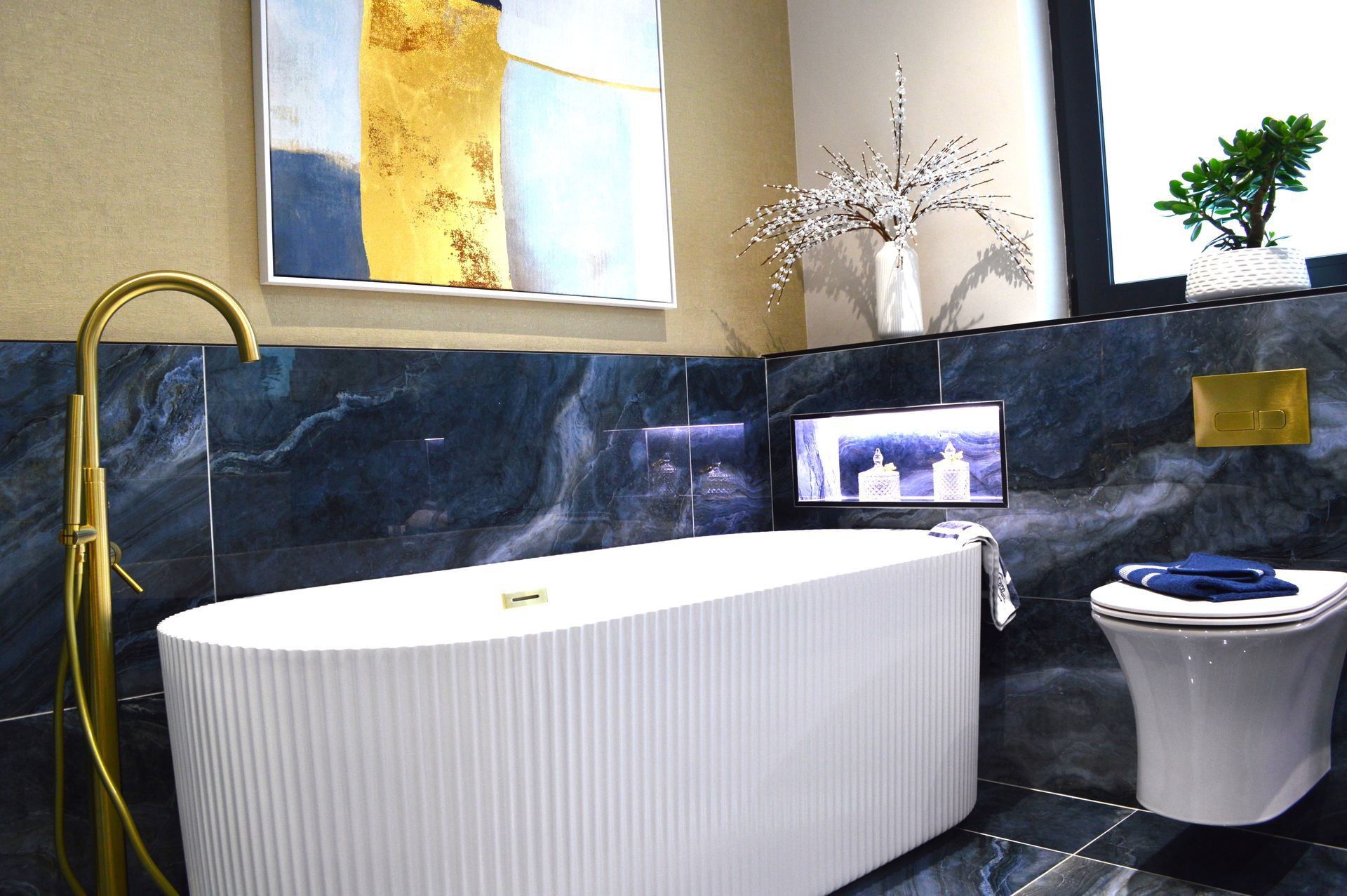 A bathroom with a bathtub , toilet , and a painting on the wall.