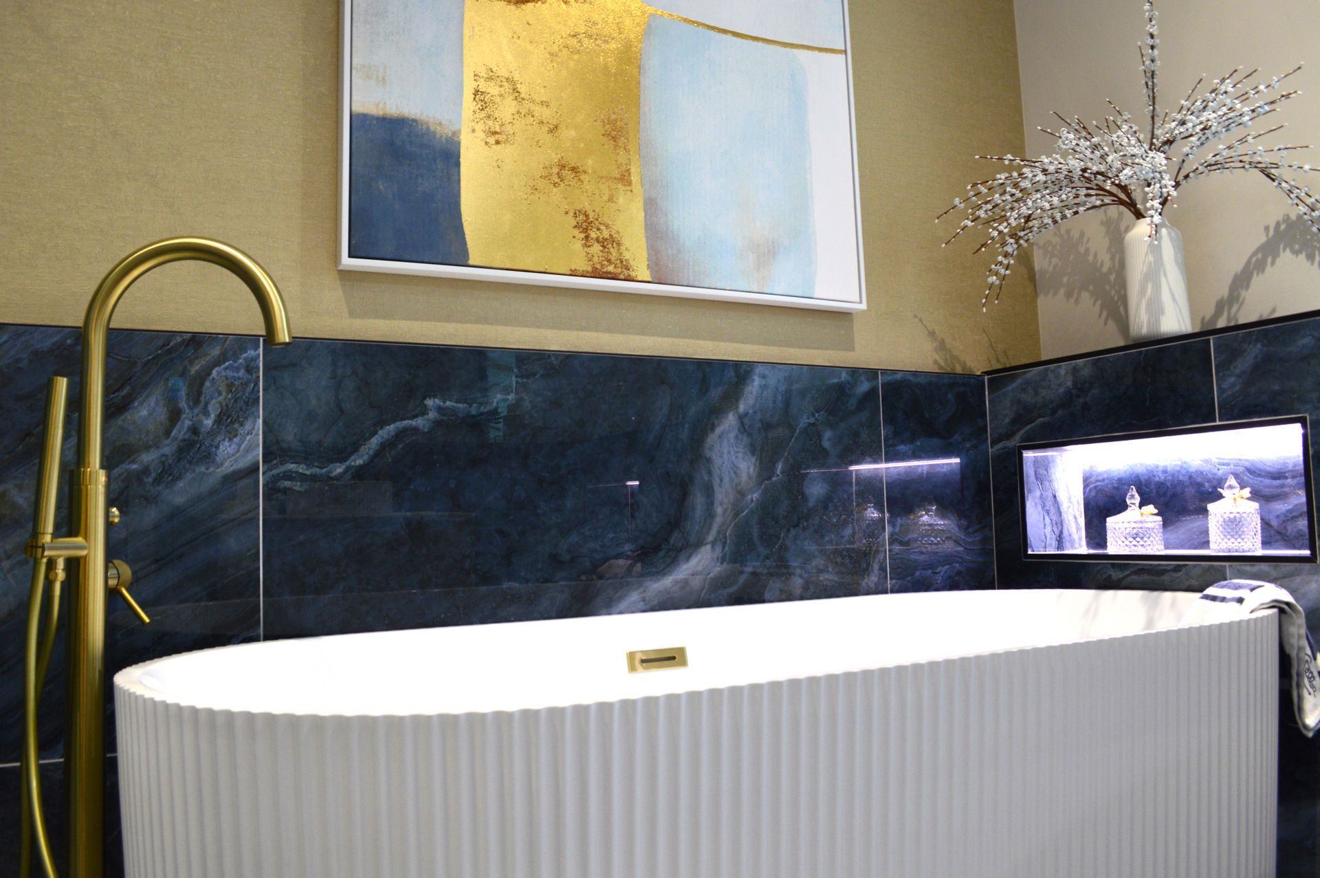 A bathroom with a bathtub and a painting on the wall.