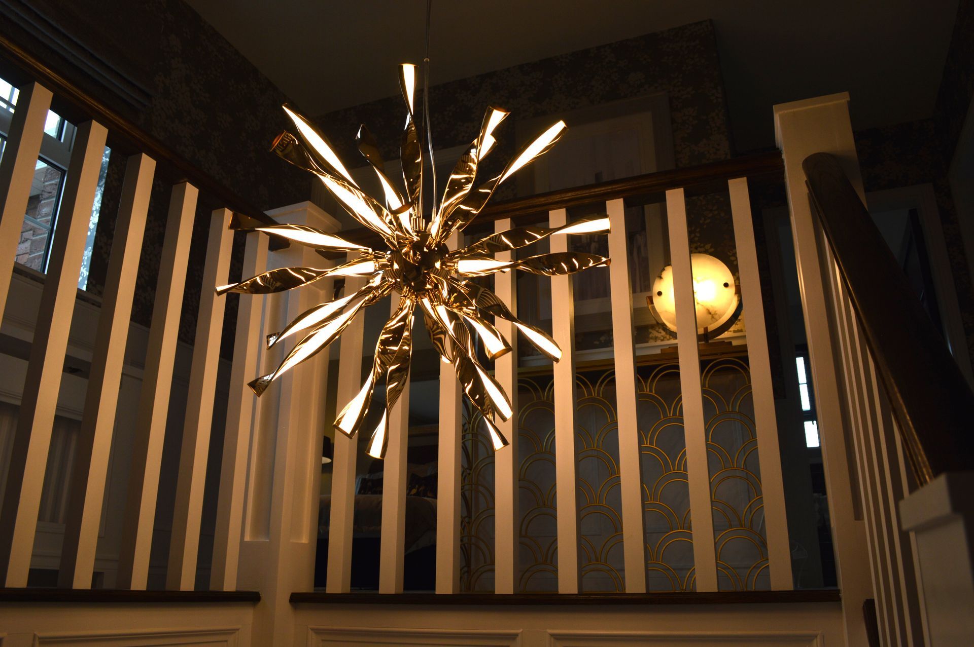 A staircase with a chandelier hanging from the ceiling