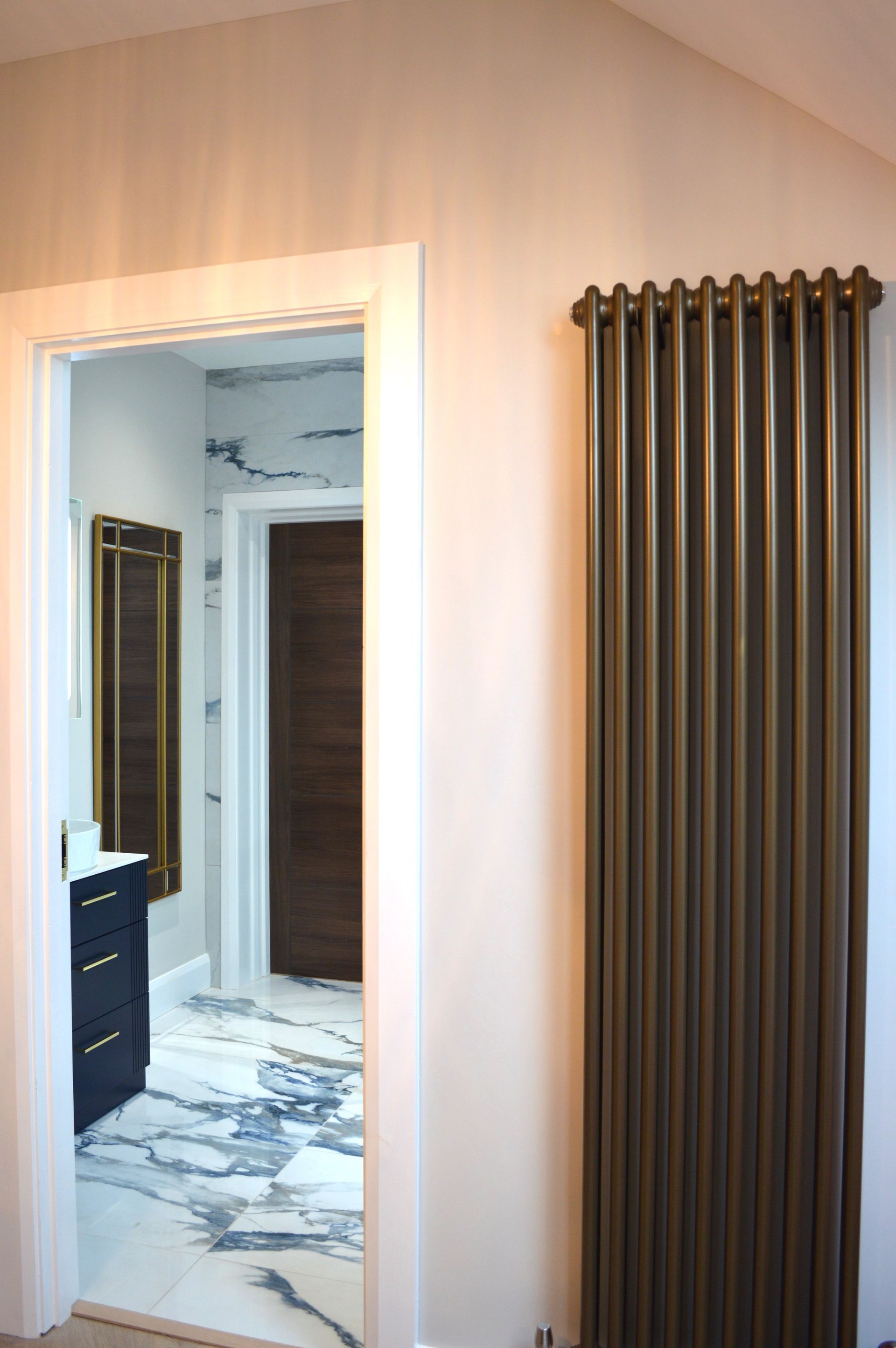 A bathroom with a radiator and a door leading to it.