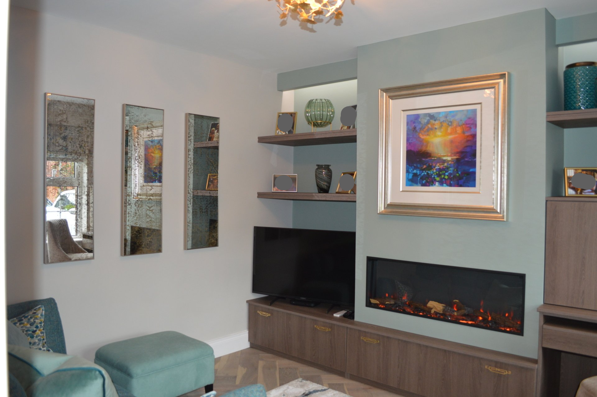 A living room with a fireplace and a painting on the wall.