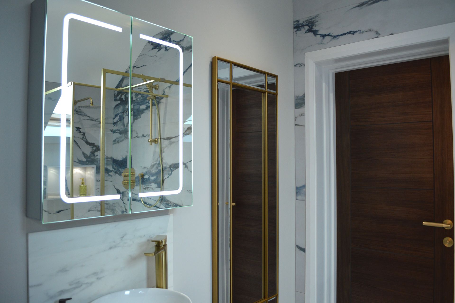 A bathroom with two mirrors , a sink and a medicine cabinet.