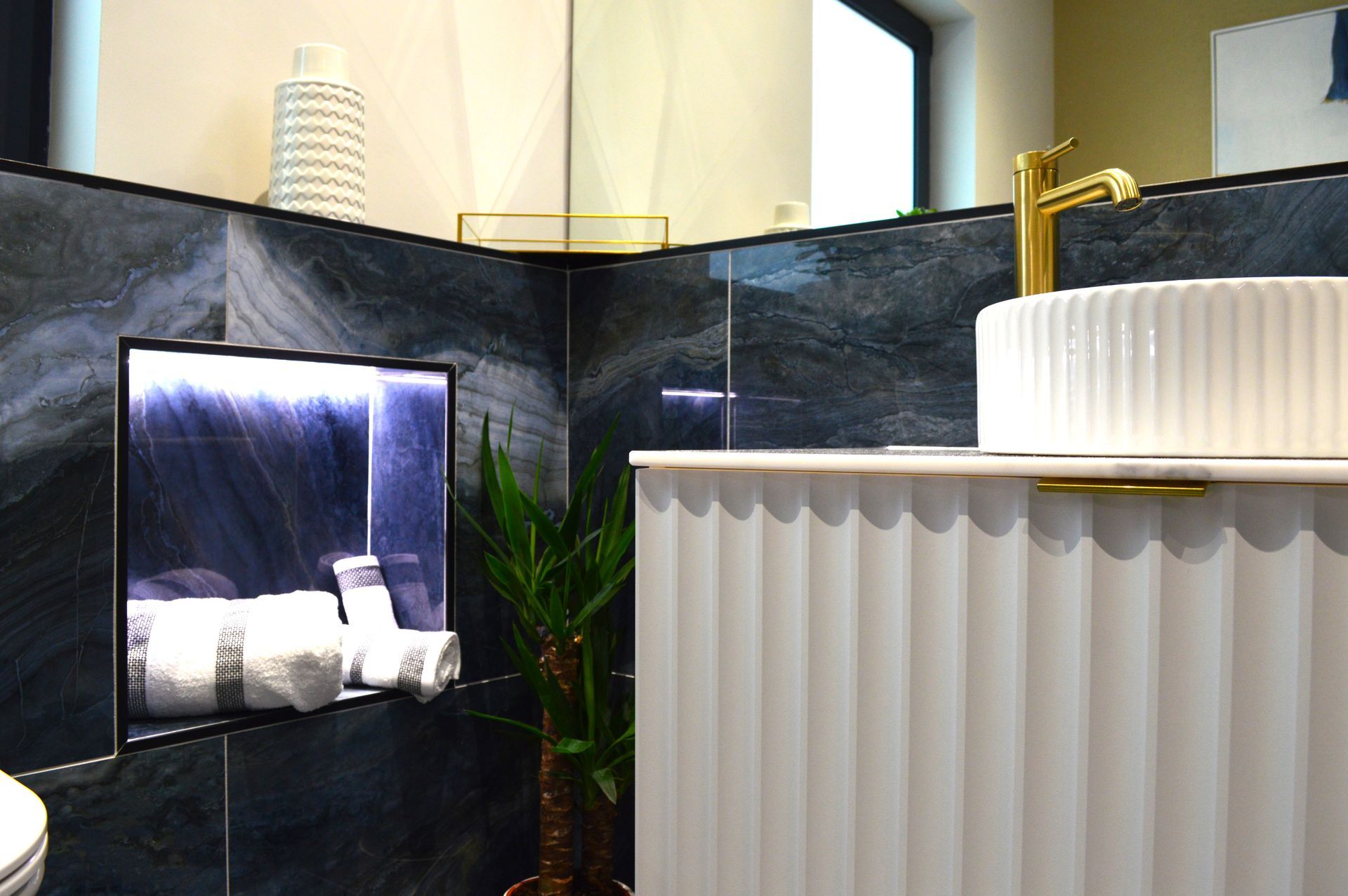 A bathroom with a sink , toilet and mirror.