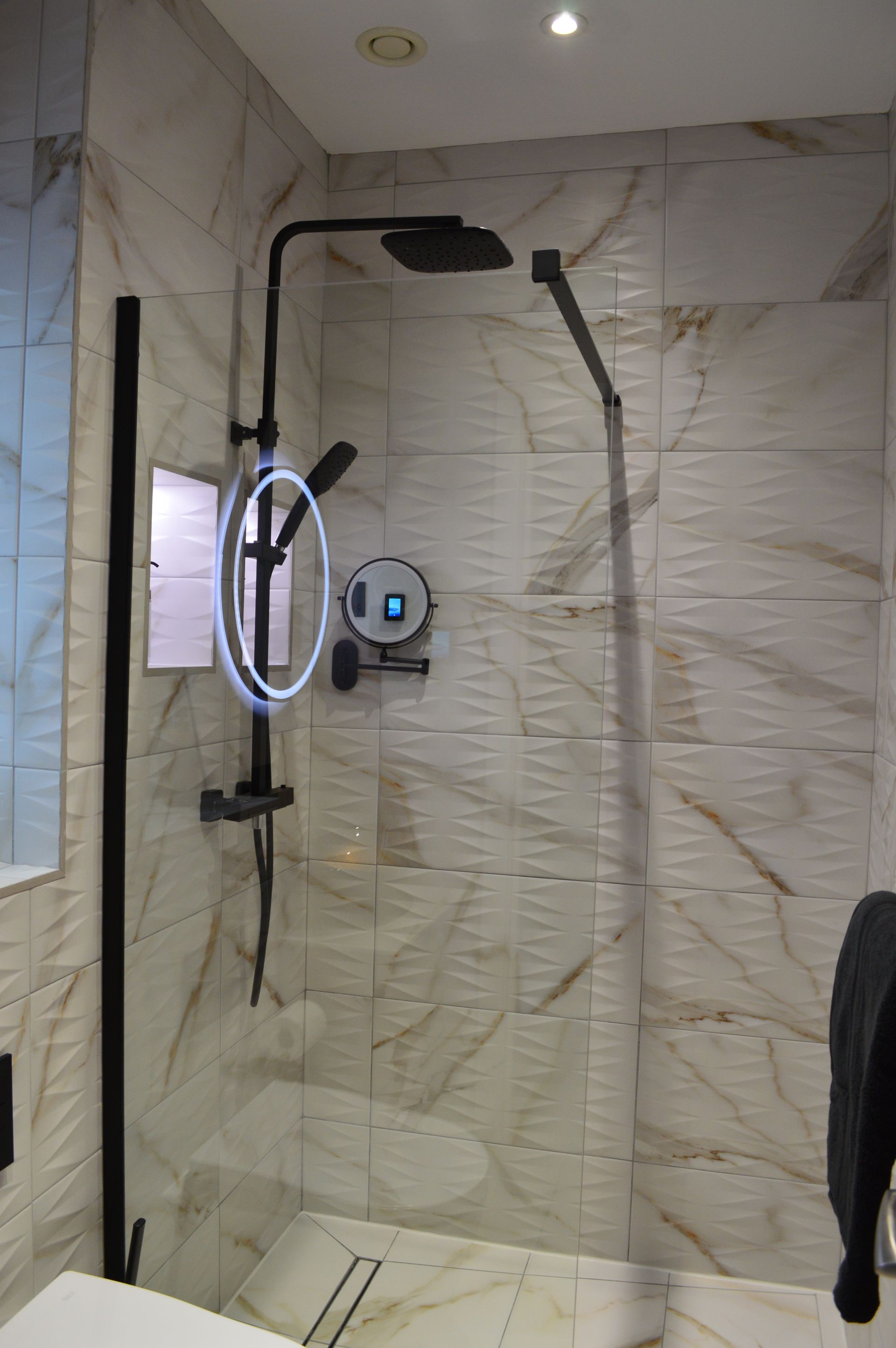 A bathroom with a walk in shower and a mirror.