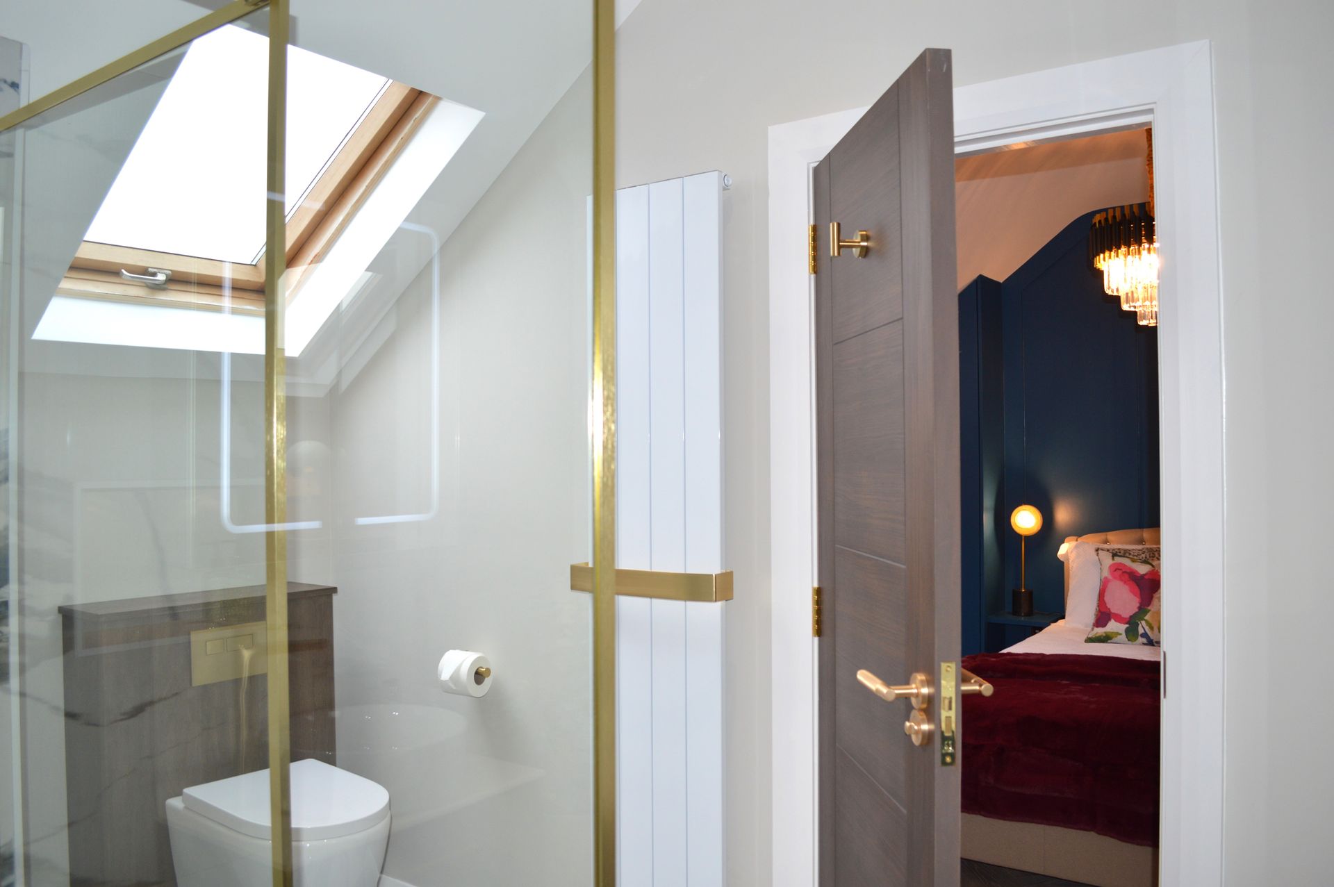 A bathroom with a toilet and a door leading to a bedroom