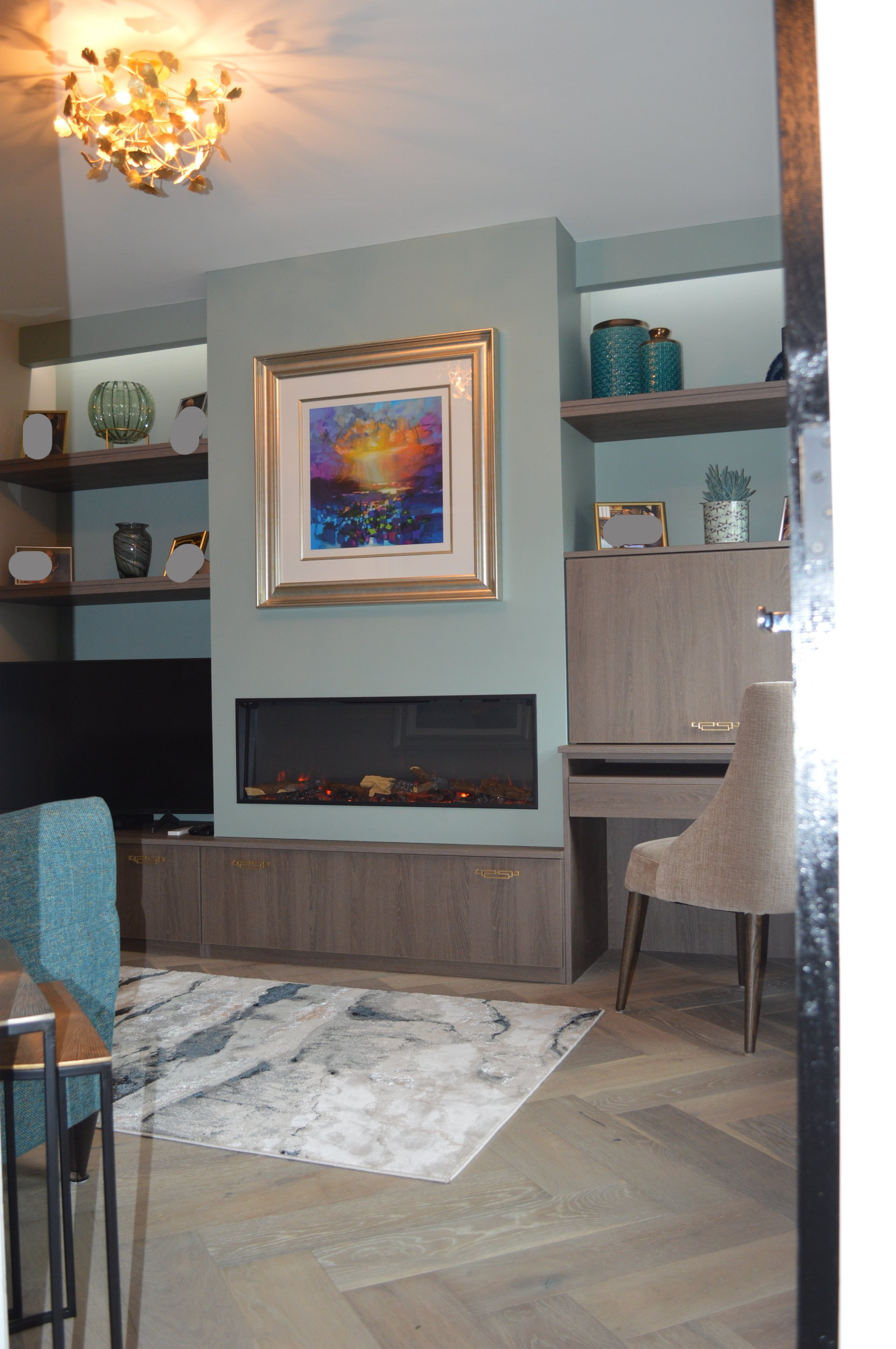 A living room with a fireplace and a painting on the wall