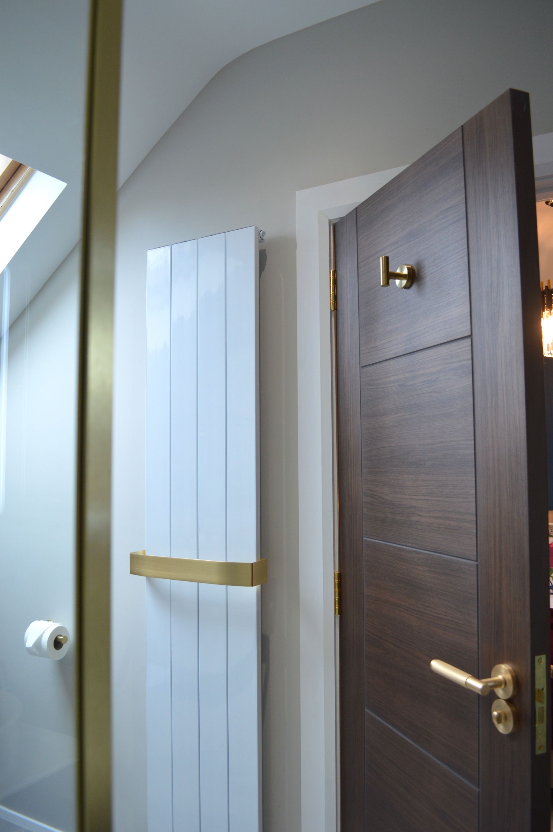 A bathroom with a wooden door and a white radiator