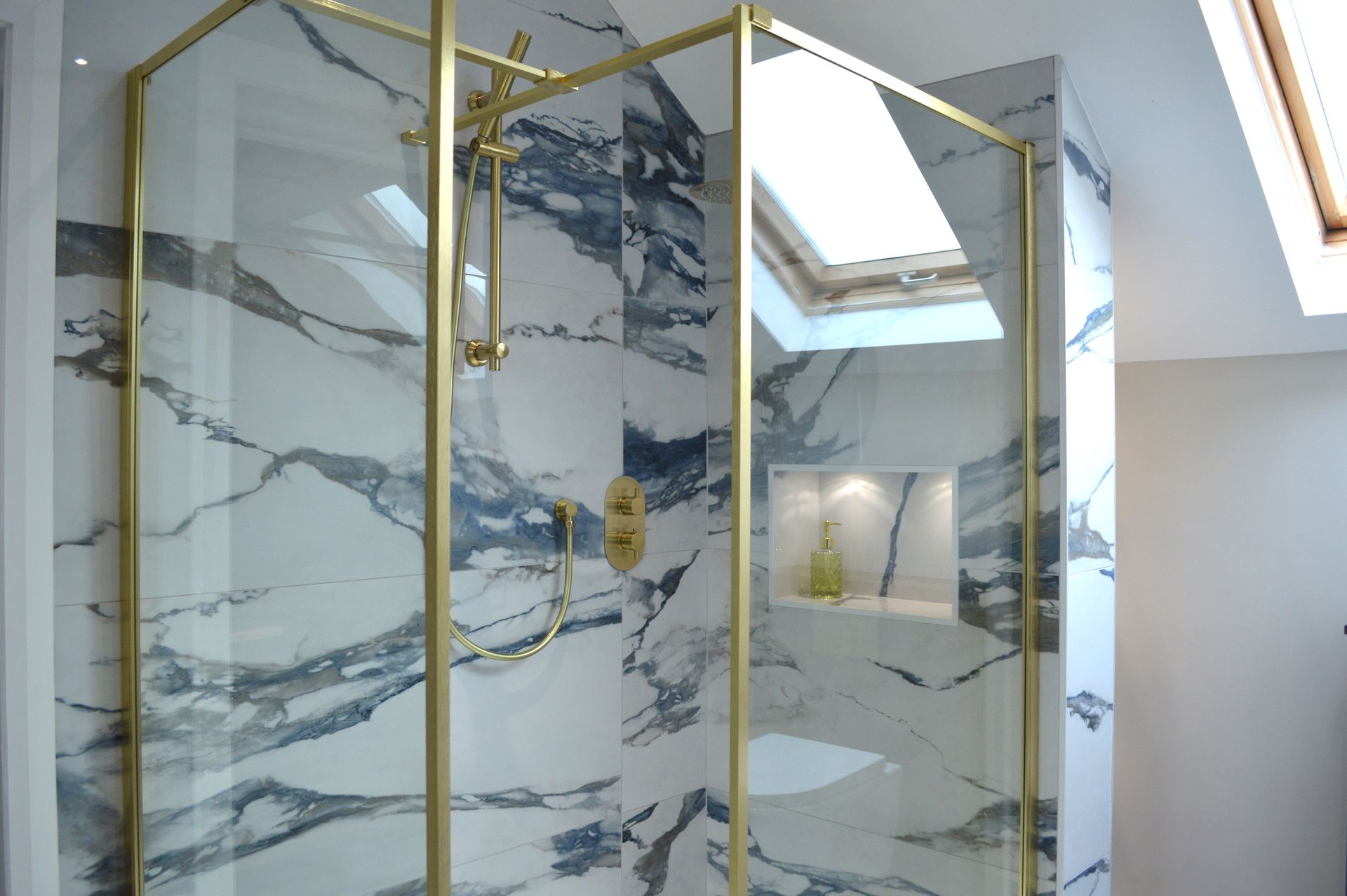 A bathroom with a walk in shower and a skylight.