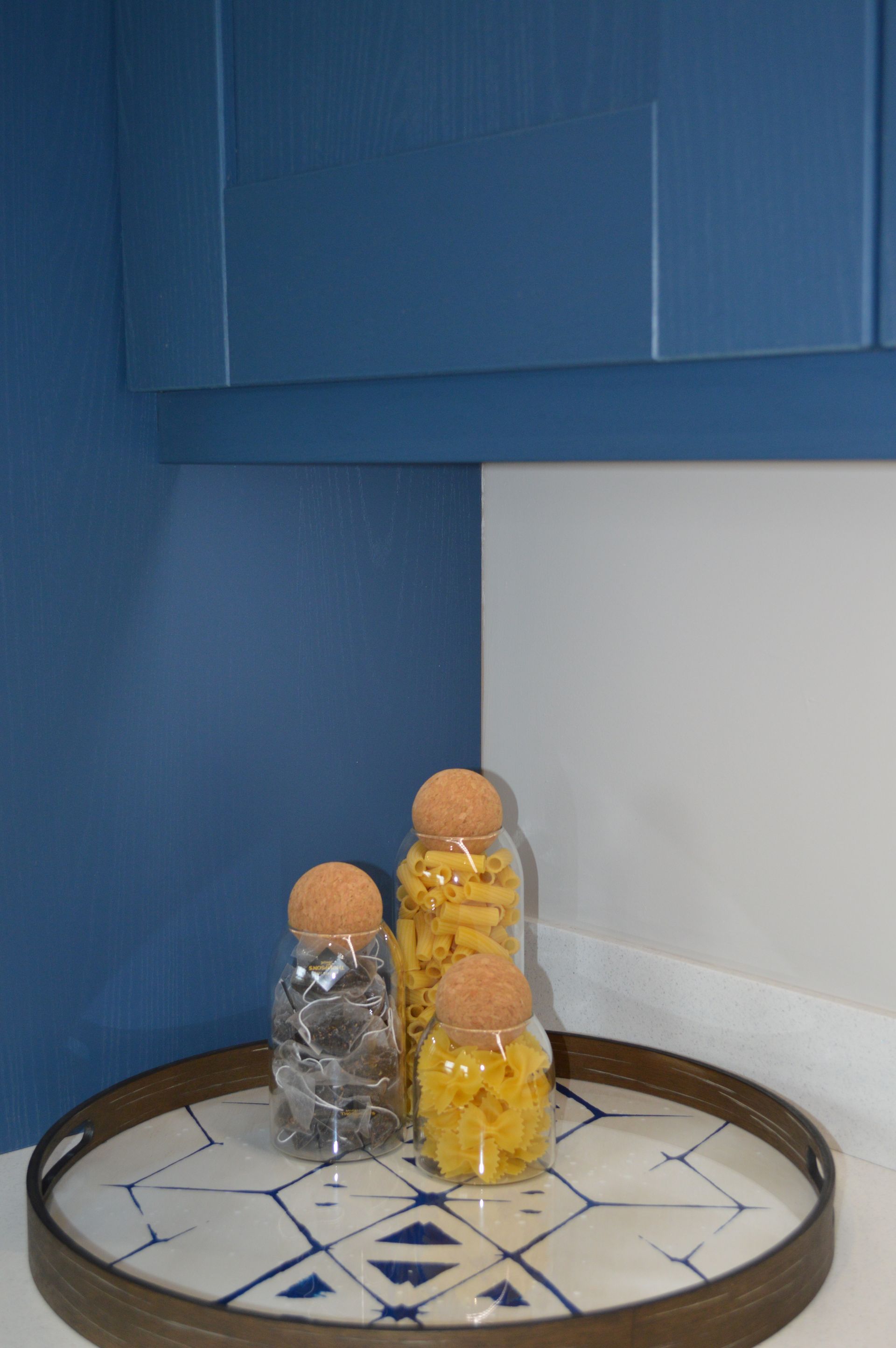 Three jars are sitting on a tray on a counter.