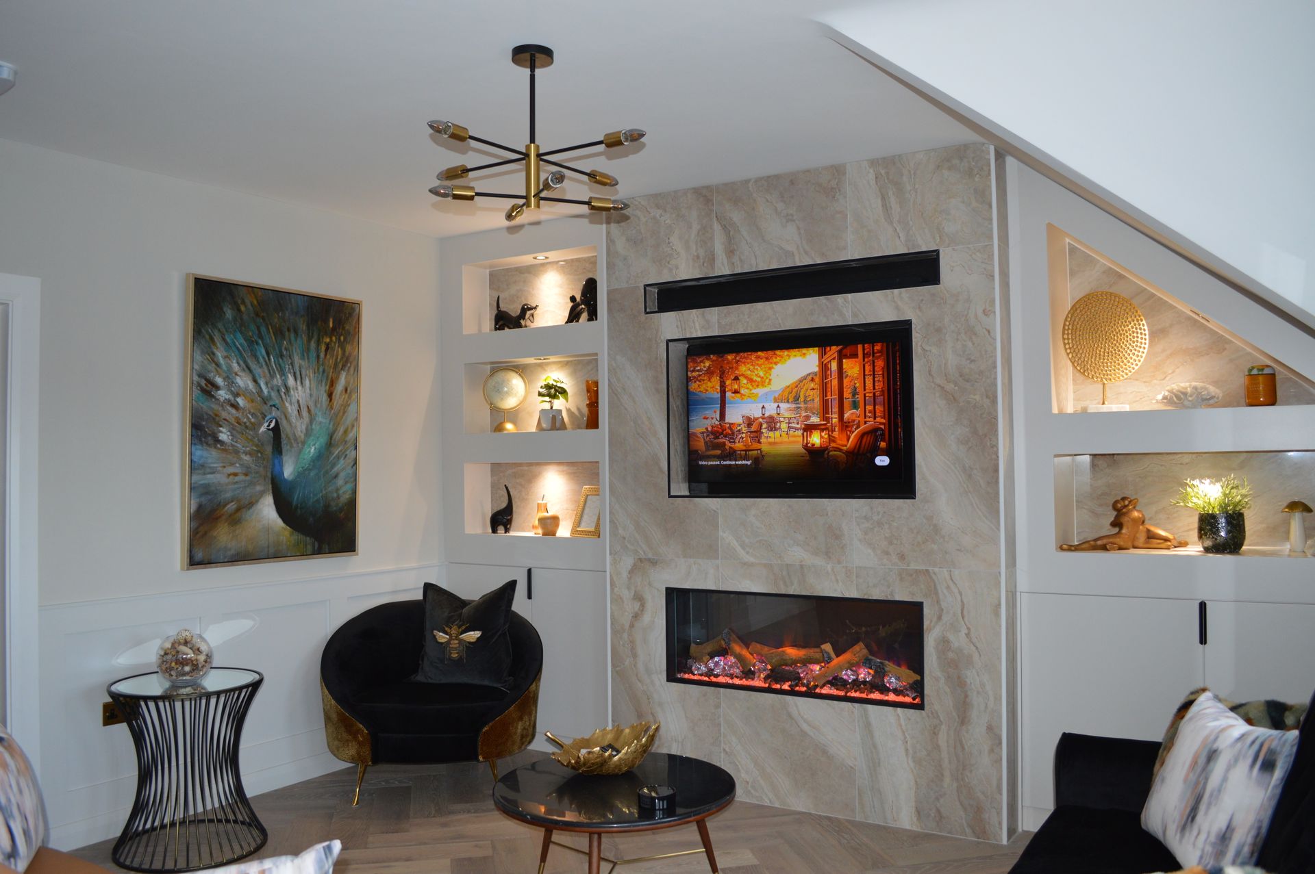 A living room with a fireplace and a television on the wall.