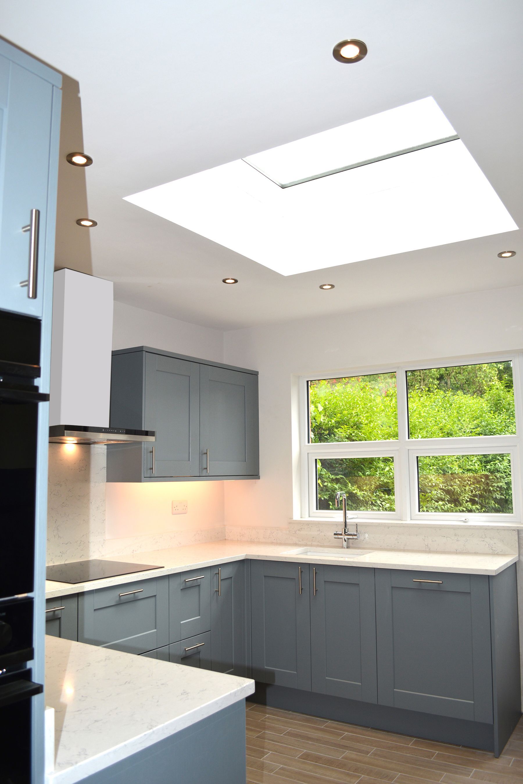 A kitchen with a skylight in the ceiling