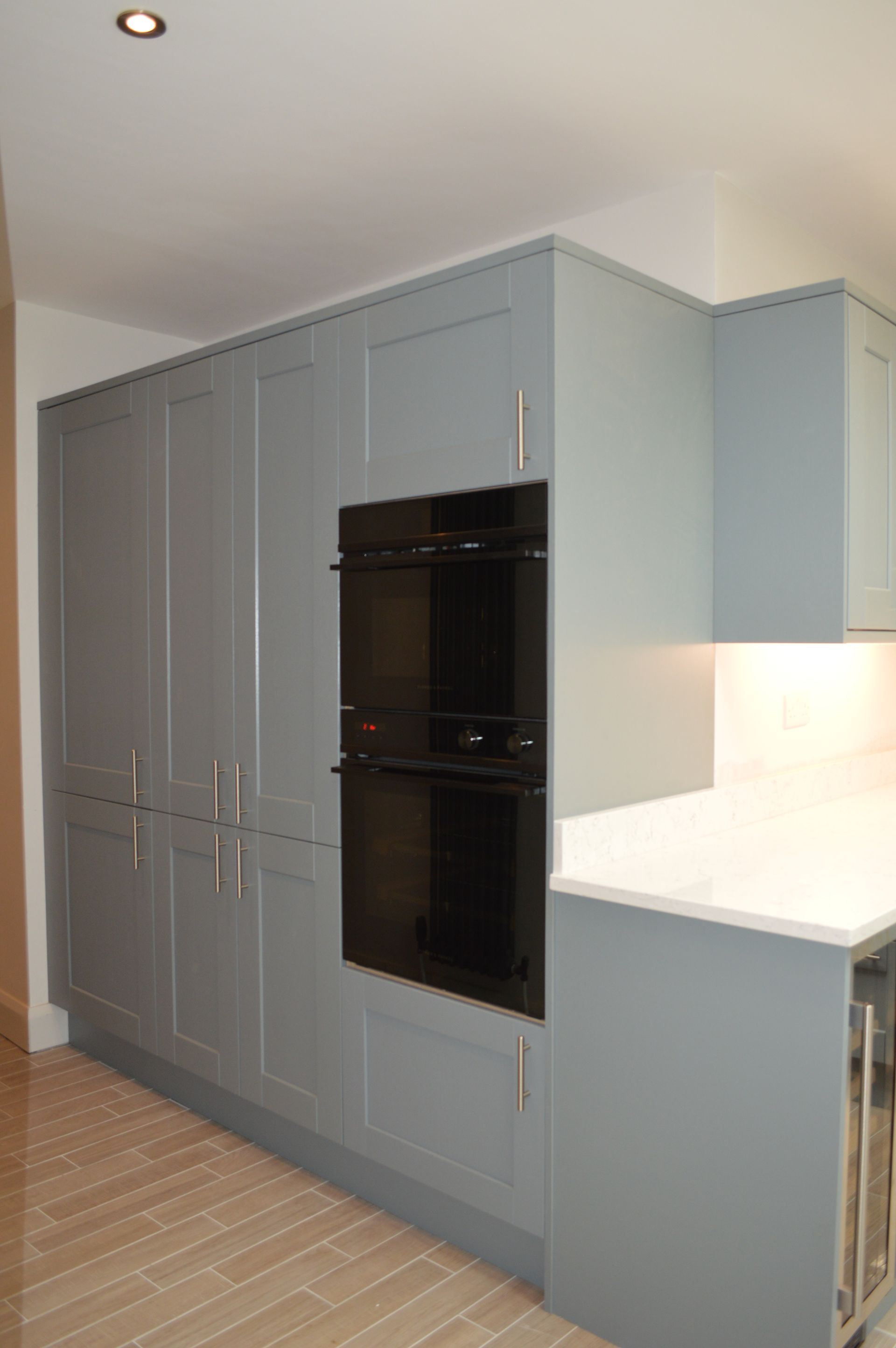 A kitchen with blue cabinets and a black oven.