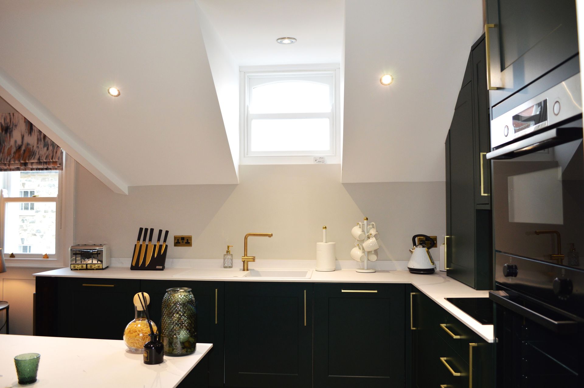 A kitchen with black cabinets and a window in the ceiling.