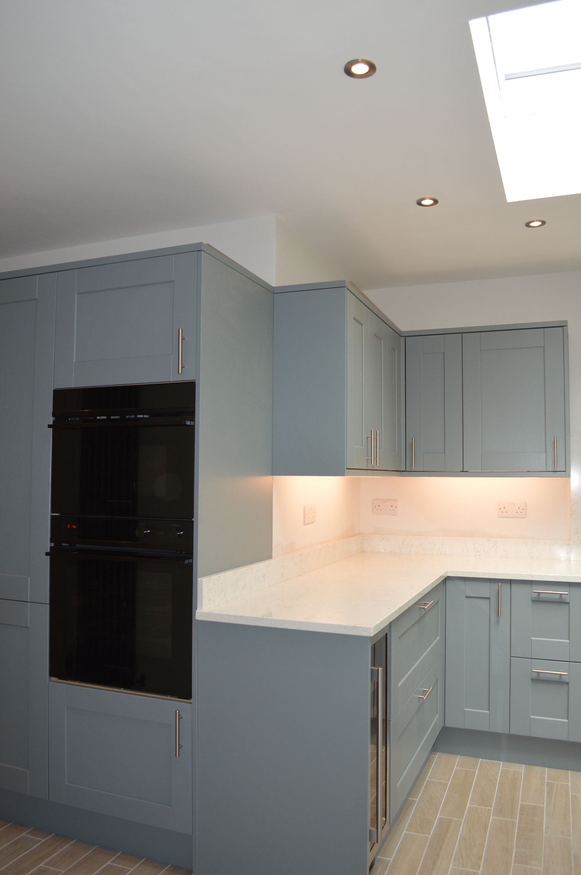 A kitchen with blue cabinets and a black oven.