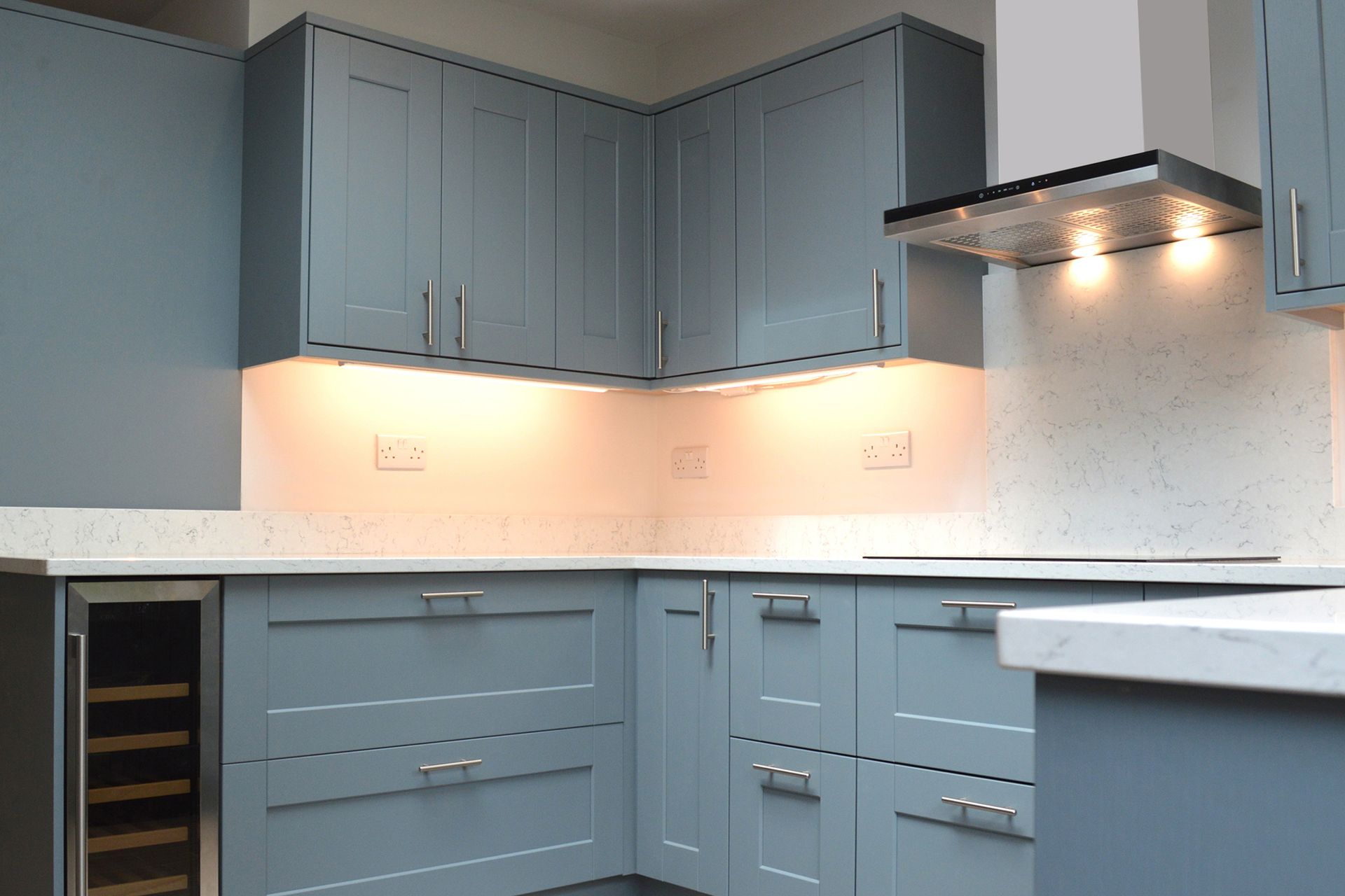 A kitchen with blue cabinets and a wine cooler