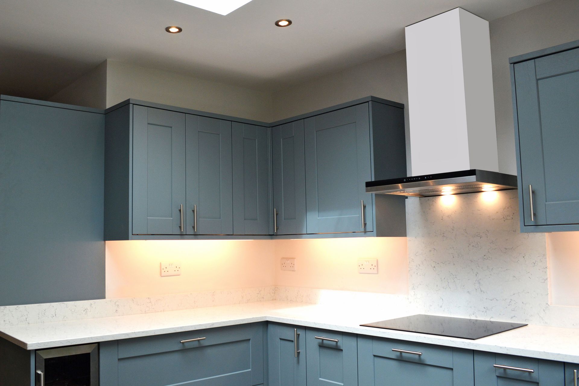 A kitchen with blue cabinets and white counter tops
