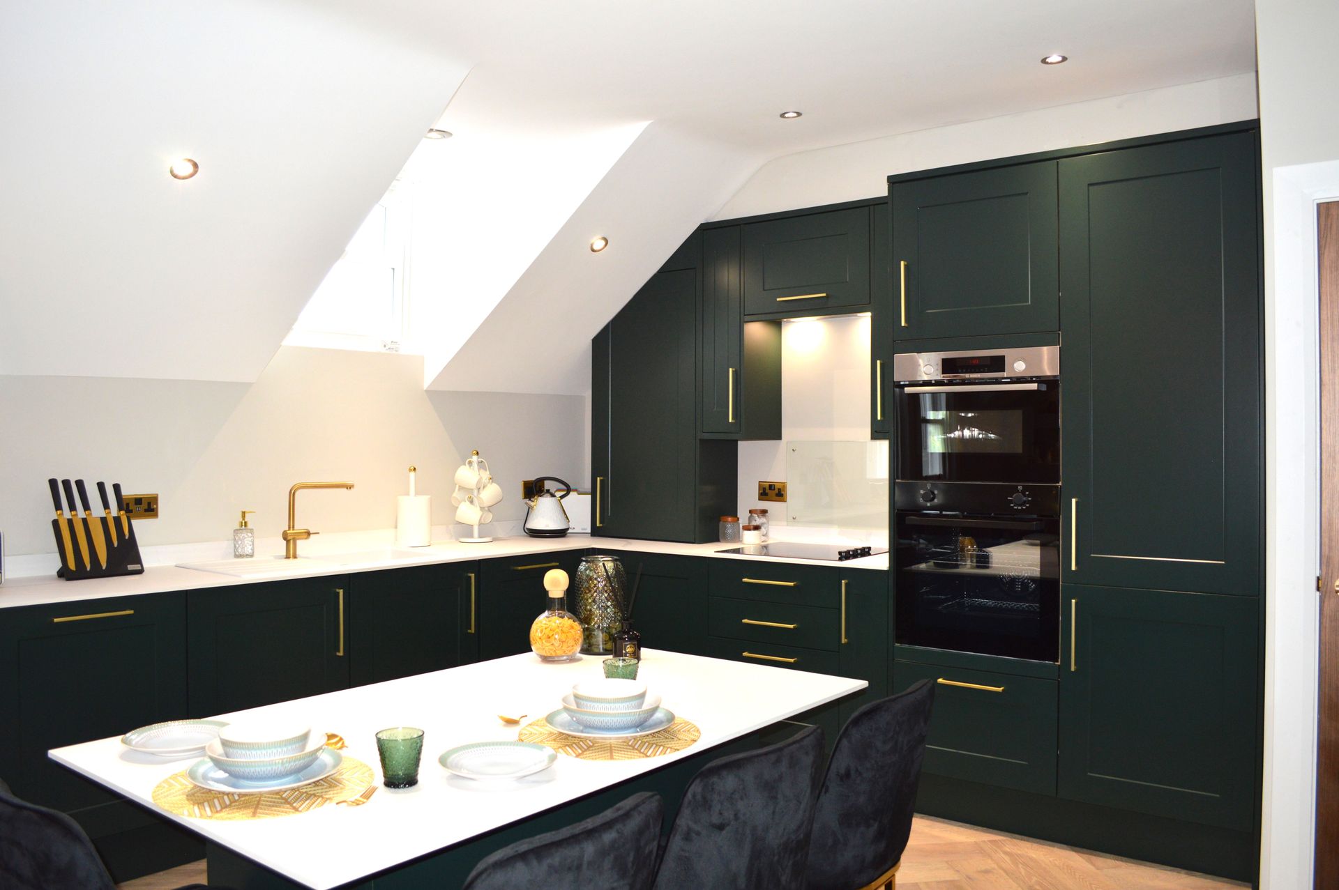 A kitchen with green cabinets and a white table and chairs.