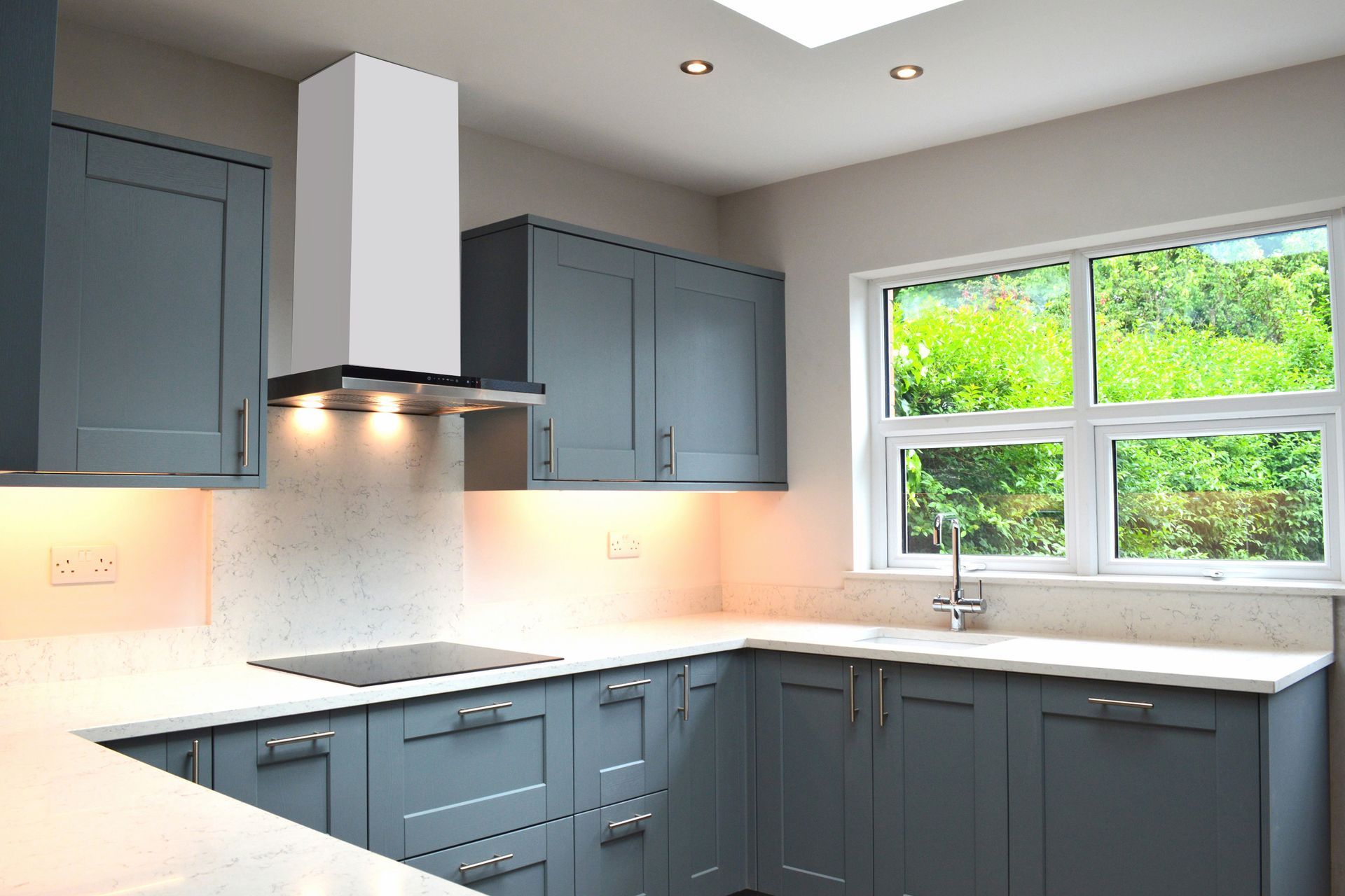 A kitchen with blue cabinets and white counter tops