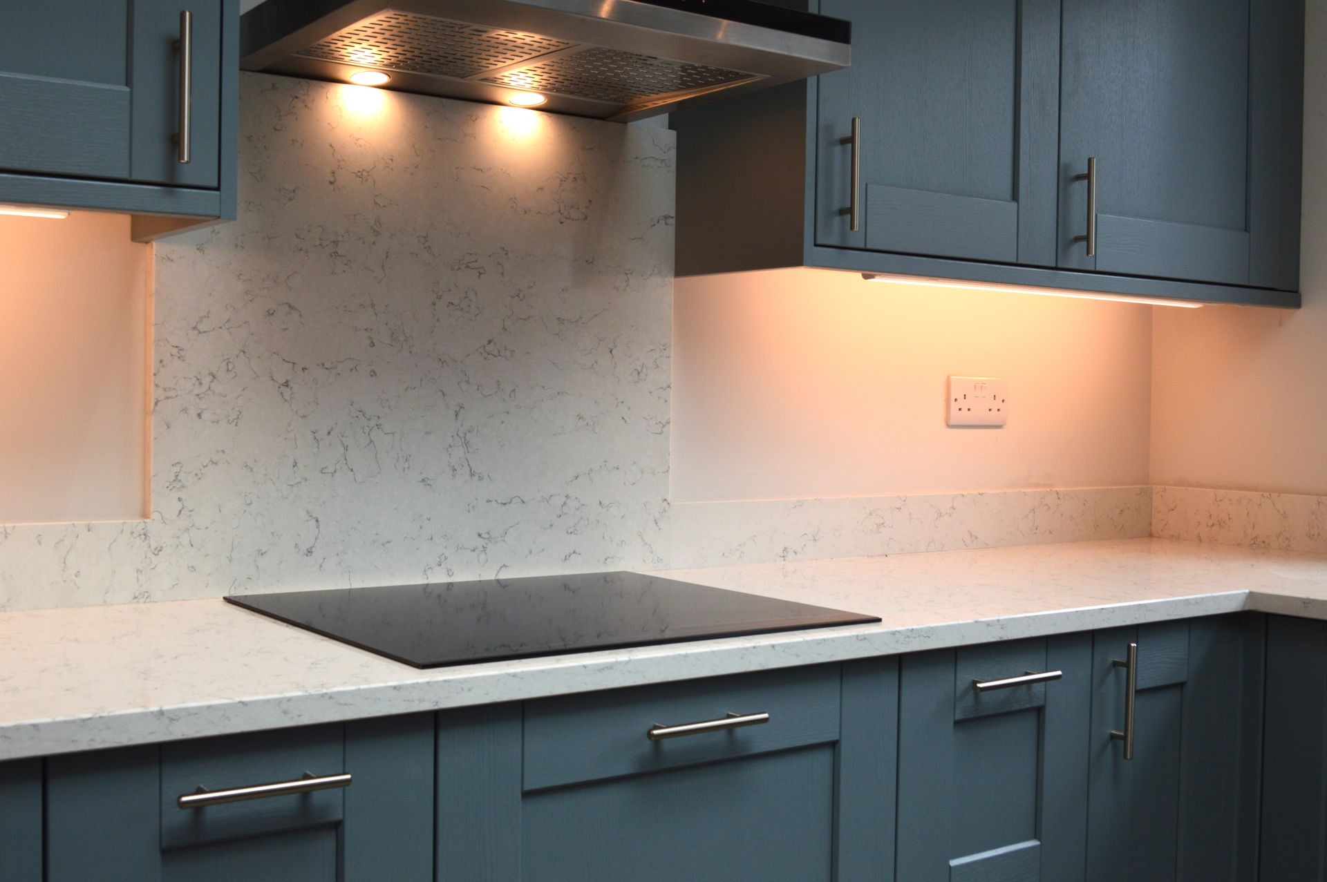 A kitchen with blue cabinets and a stove top oven.